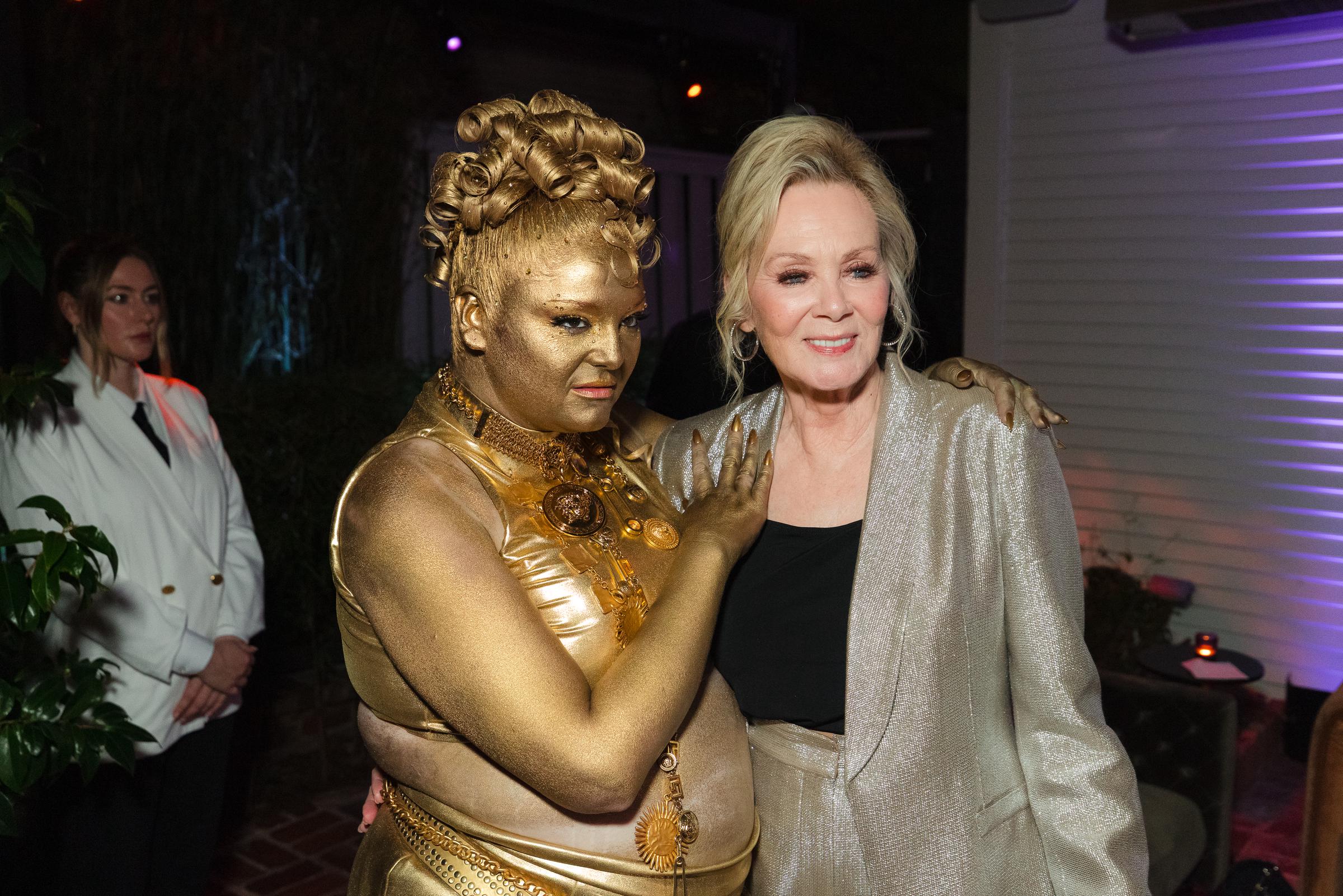 Meg Stalter pose aux côtés de Jean Smart lors de l'afterparty HBO Max : Stalter est recouverte de peinture corporelle dorée et Smart porte une veste argentée scintillante. | Source : Getty Images