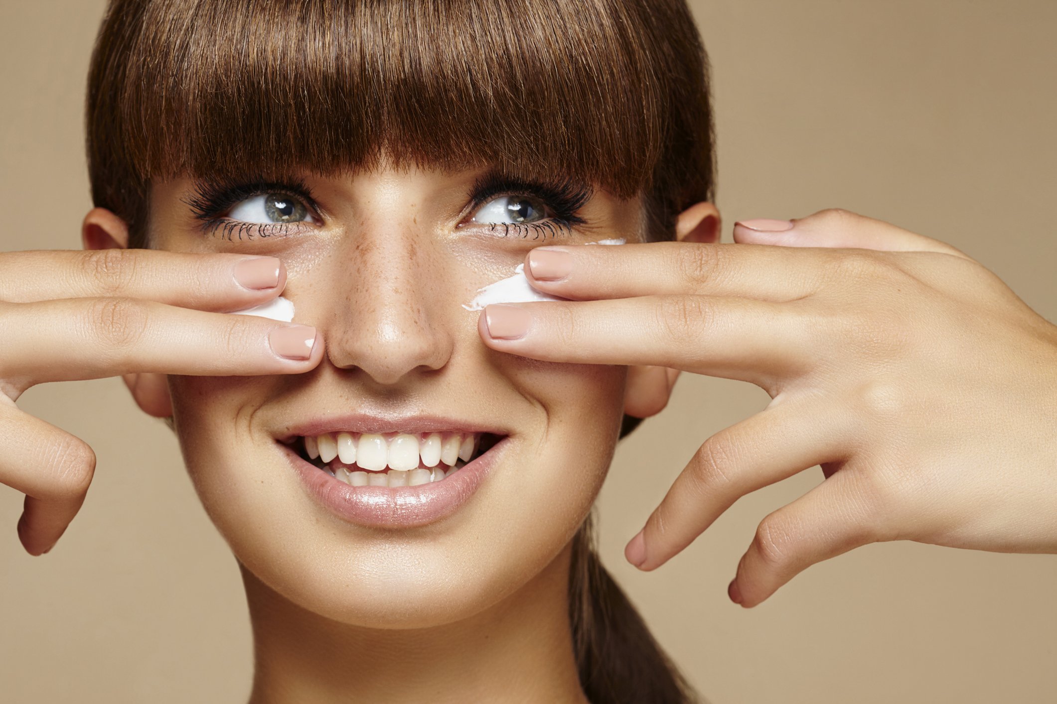 Une femme applique une crème sur son visage. | Photo : Getty Images