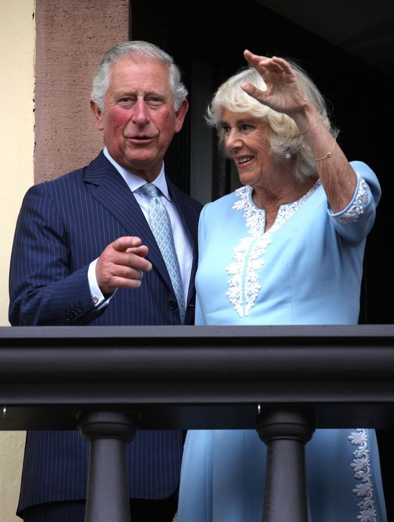 Le Prince Charles, Prince de Galles et Camilla, Duchesse de Cornouailles saluent la foule depuis le balcon de l'ancien Hôtel de Ville. | Source : Getty Images