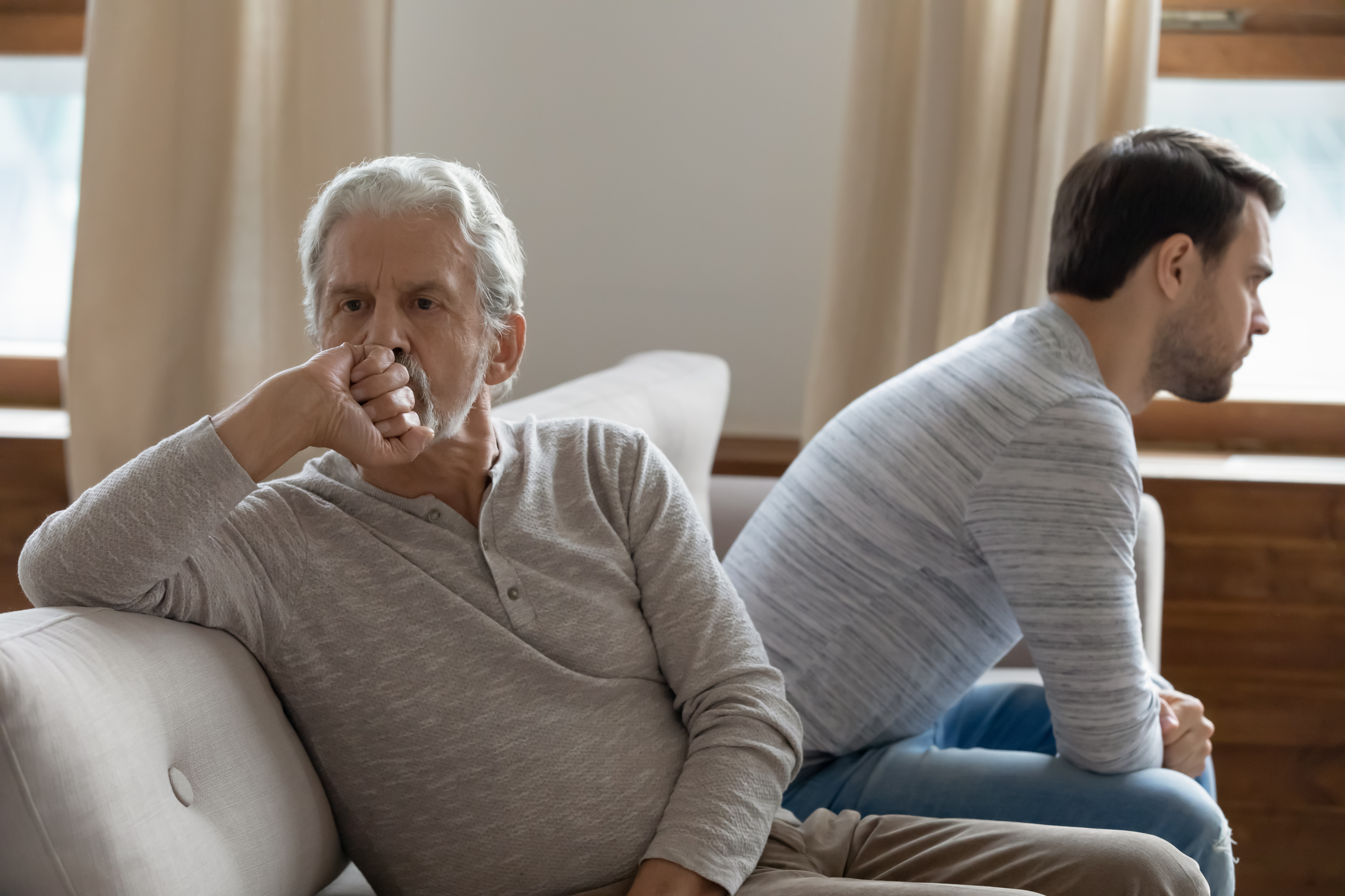 Un homme âgé malheureux assis face à un plus jeune | Source : Shutterstock