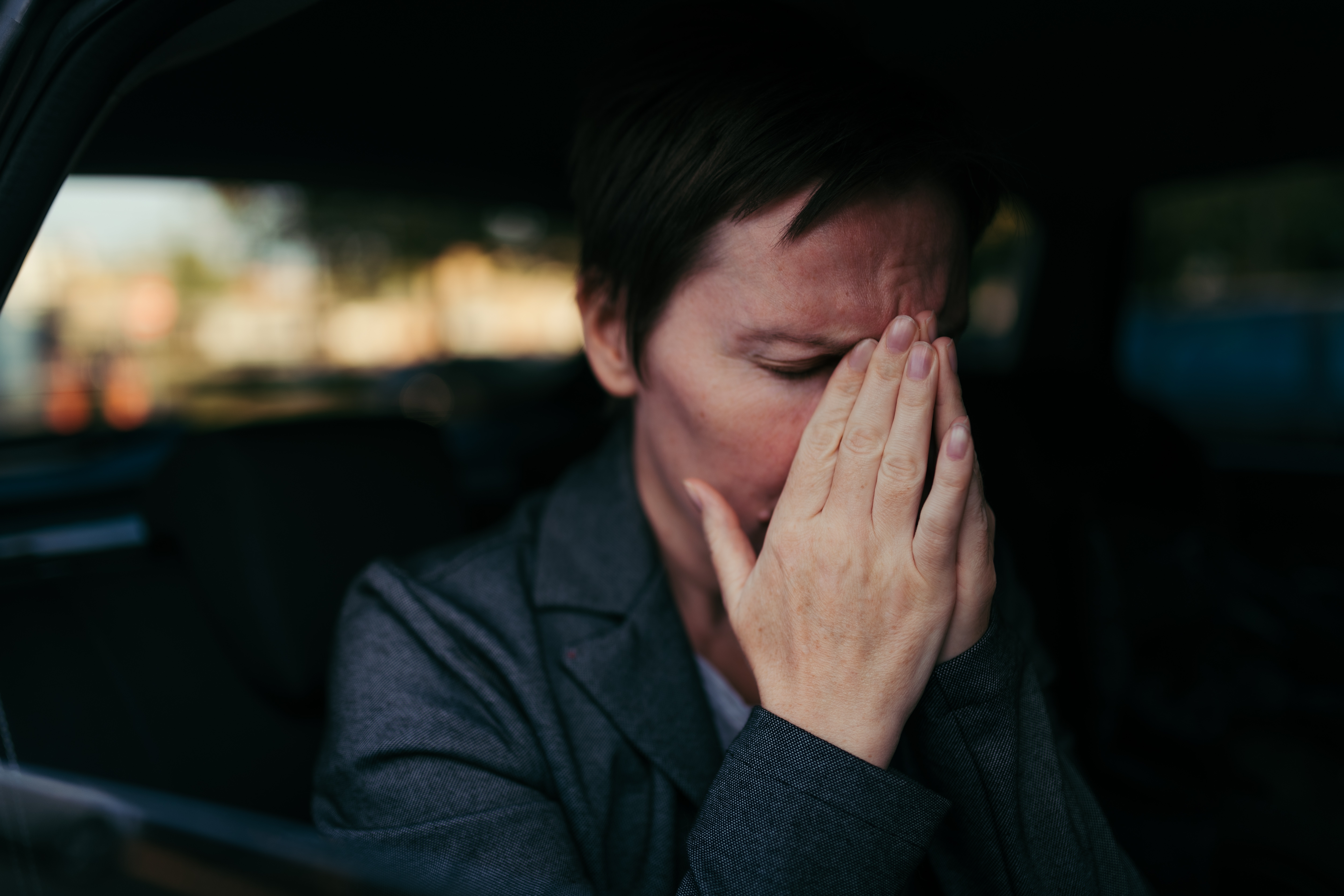 Une femme anxieuse assise à l'arrière d'une voiture | Source : Shutterstock