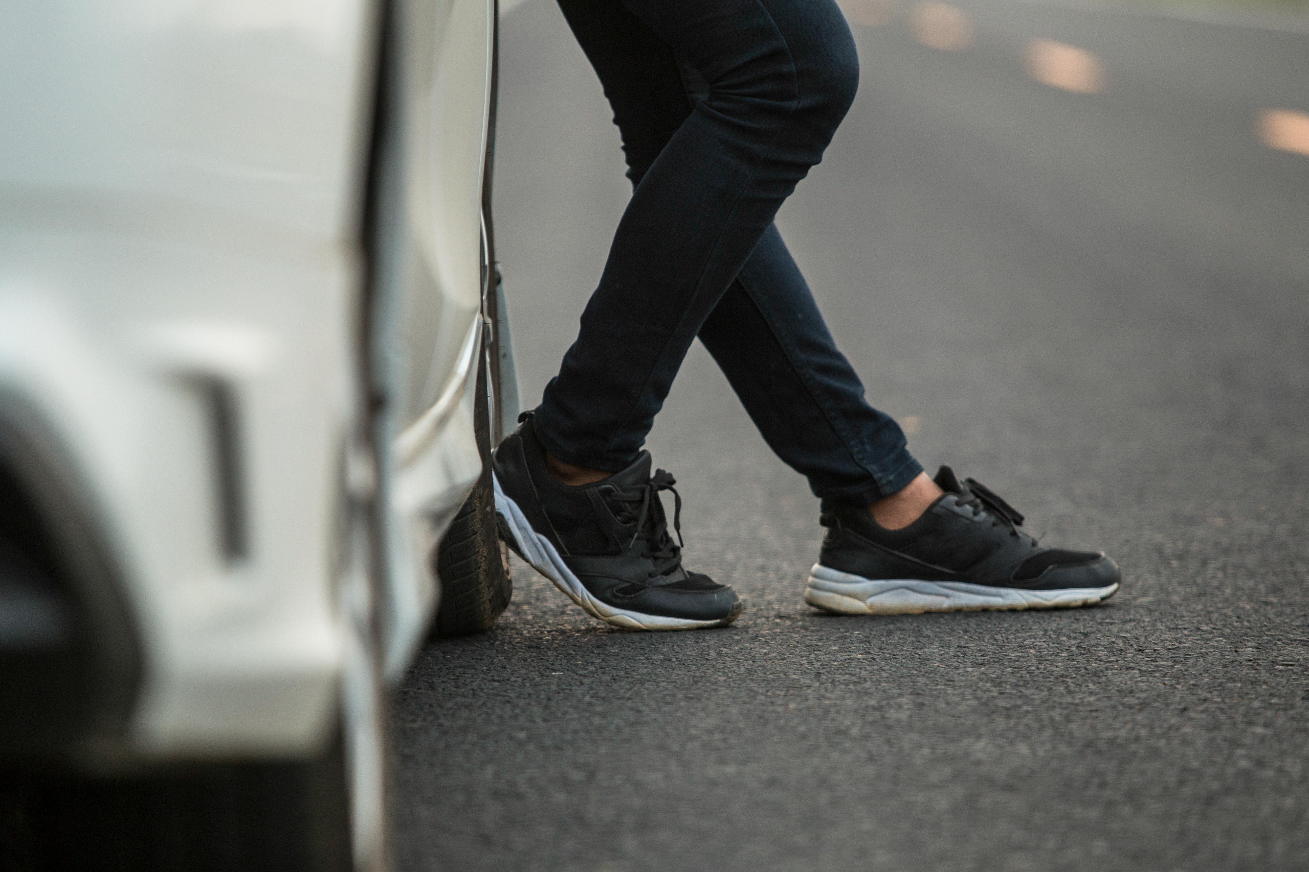 Pés em tênis ao lado de um carro |  Fonte: Shutterstock