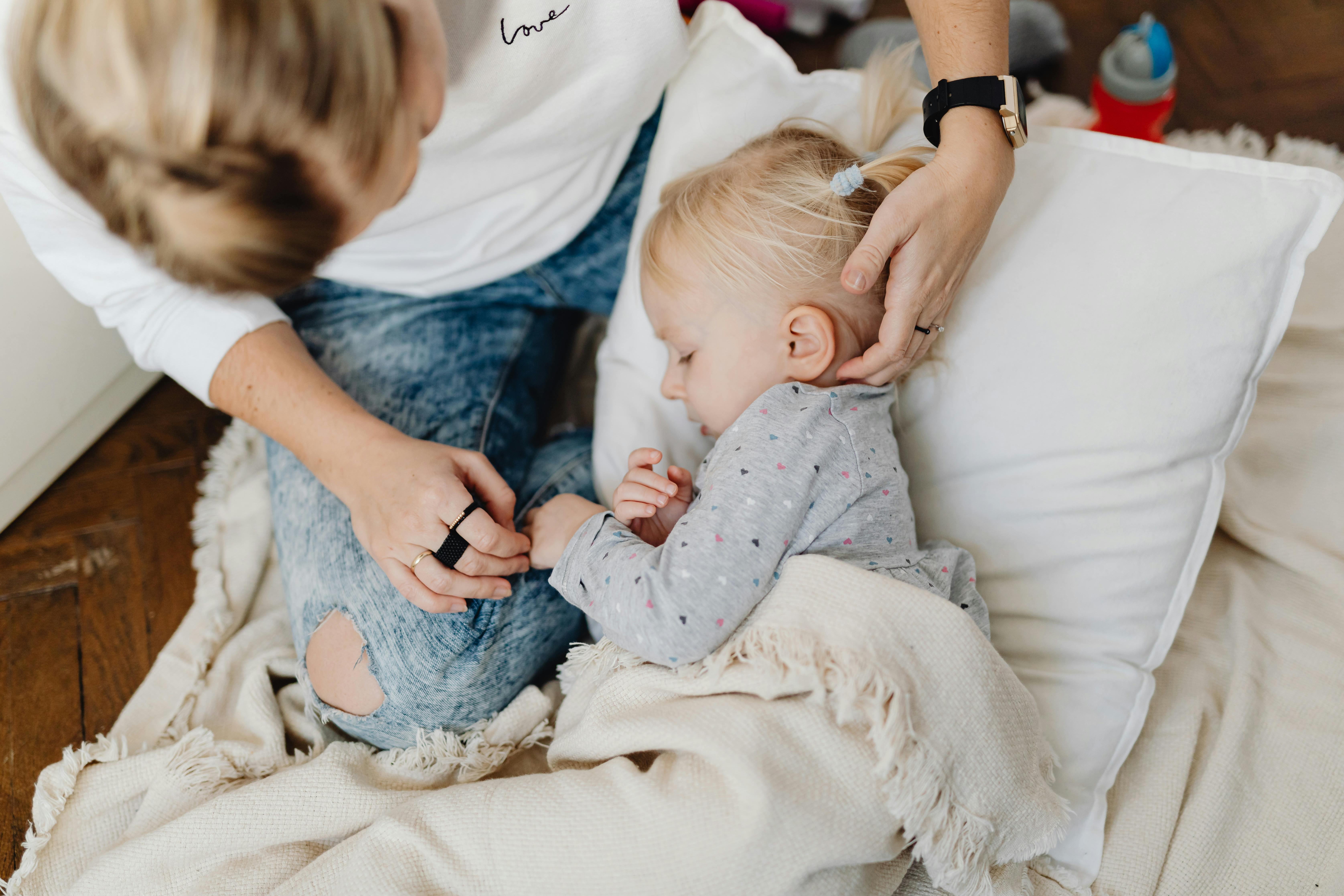 Femme bordant sa fille dans son lit | Source : Pexels