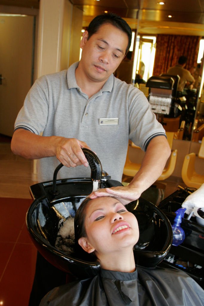 Une femme qui fait ses soins de cheveux chez un coiffeur. | Photo : Getty Images