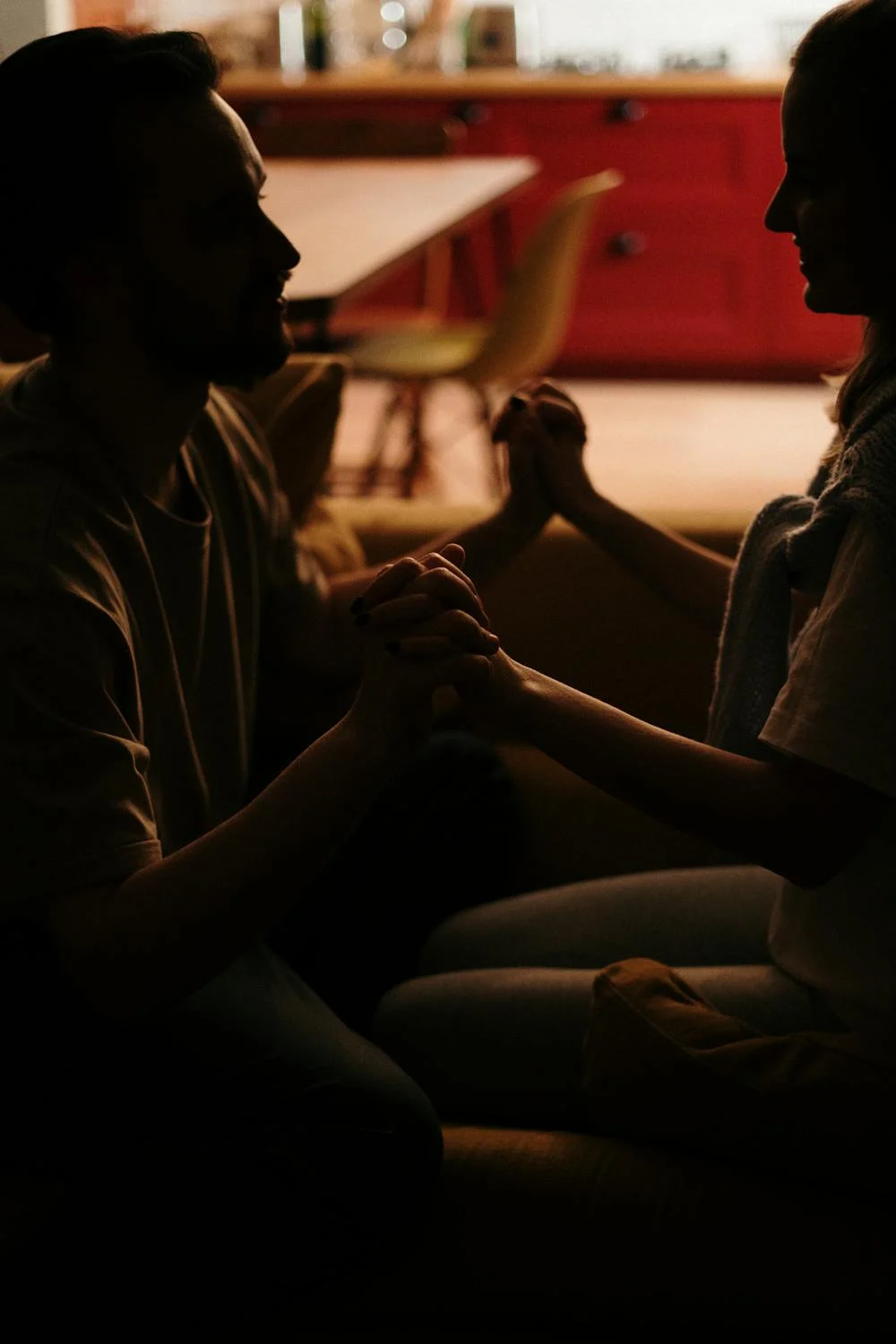 Un homme tenant la main de sa femme dans l'obscurité | Source : Pexels