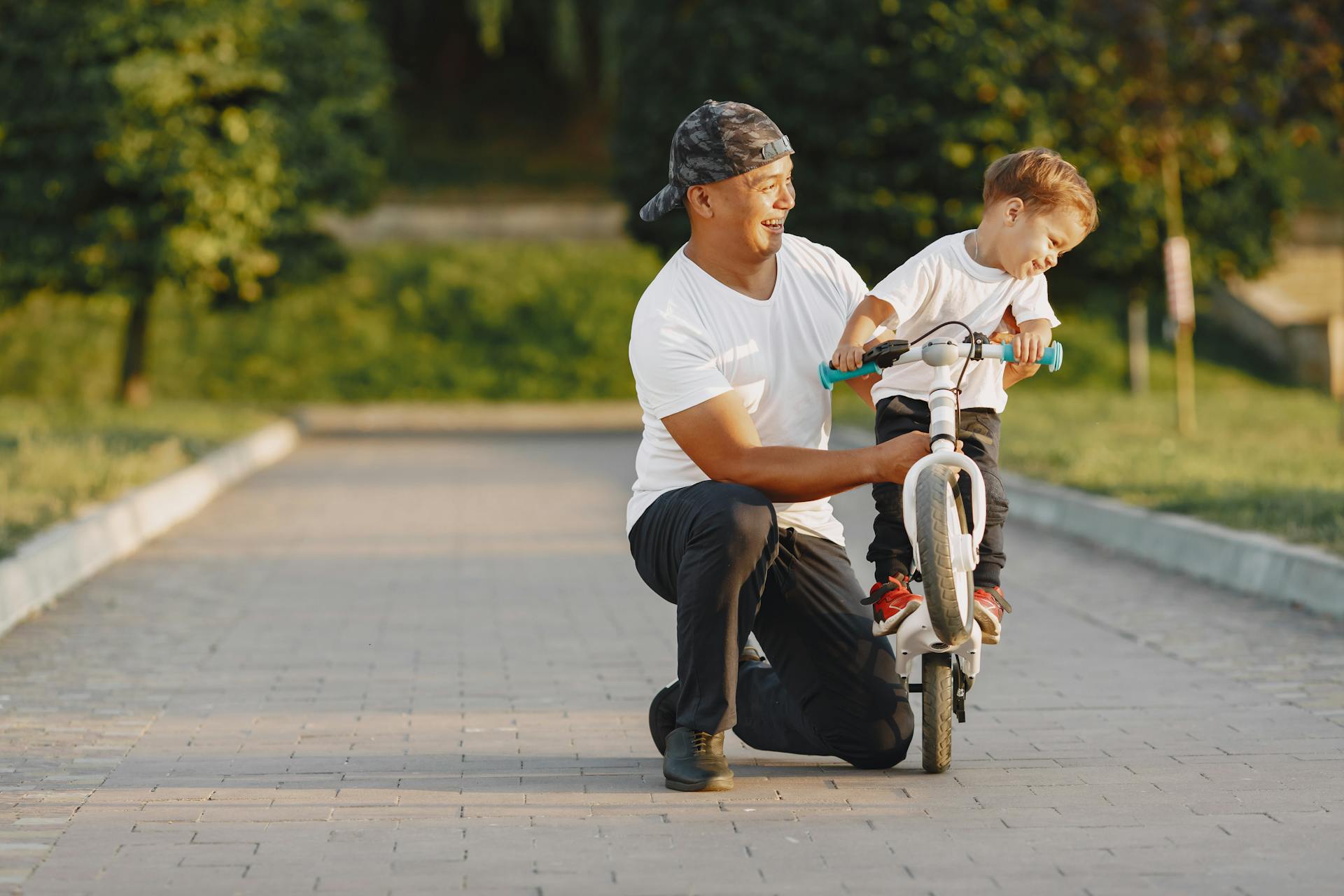 Un homme apprend à un petit garçon à faire du vélo | Source : Pexels