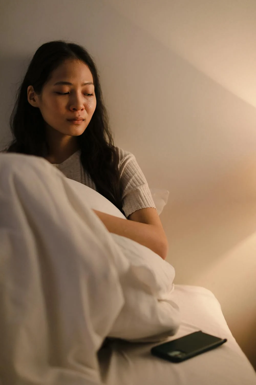 Une femme qui pleure dans son lit | Source : Pexels