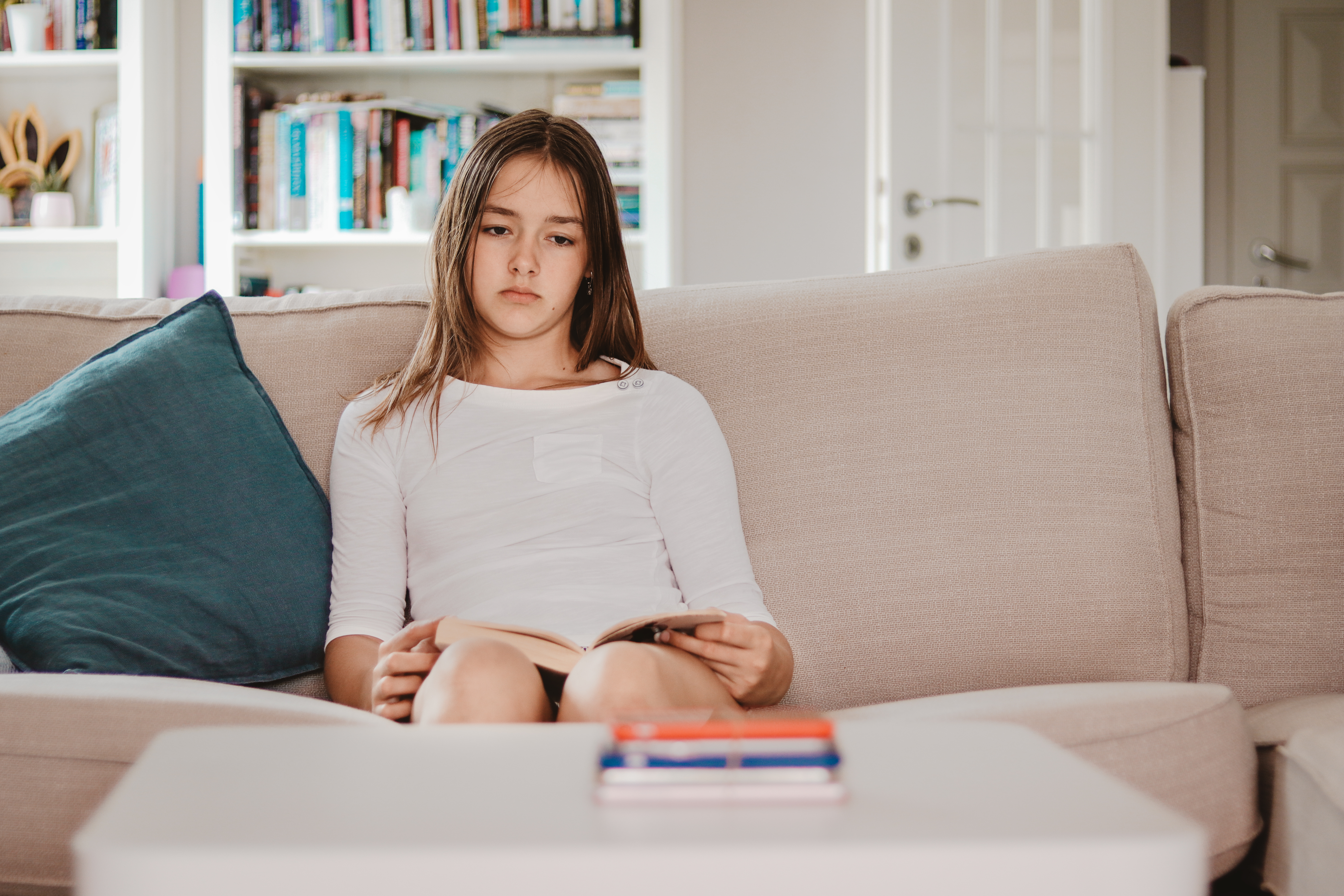 Une jeune fille assise sur un canapé, l'air triste | Source : Shutterstock