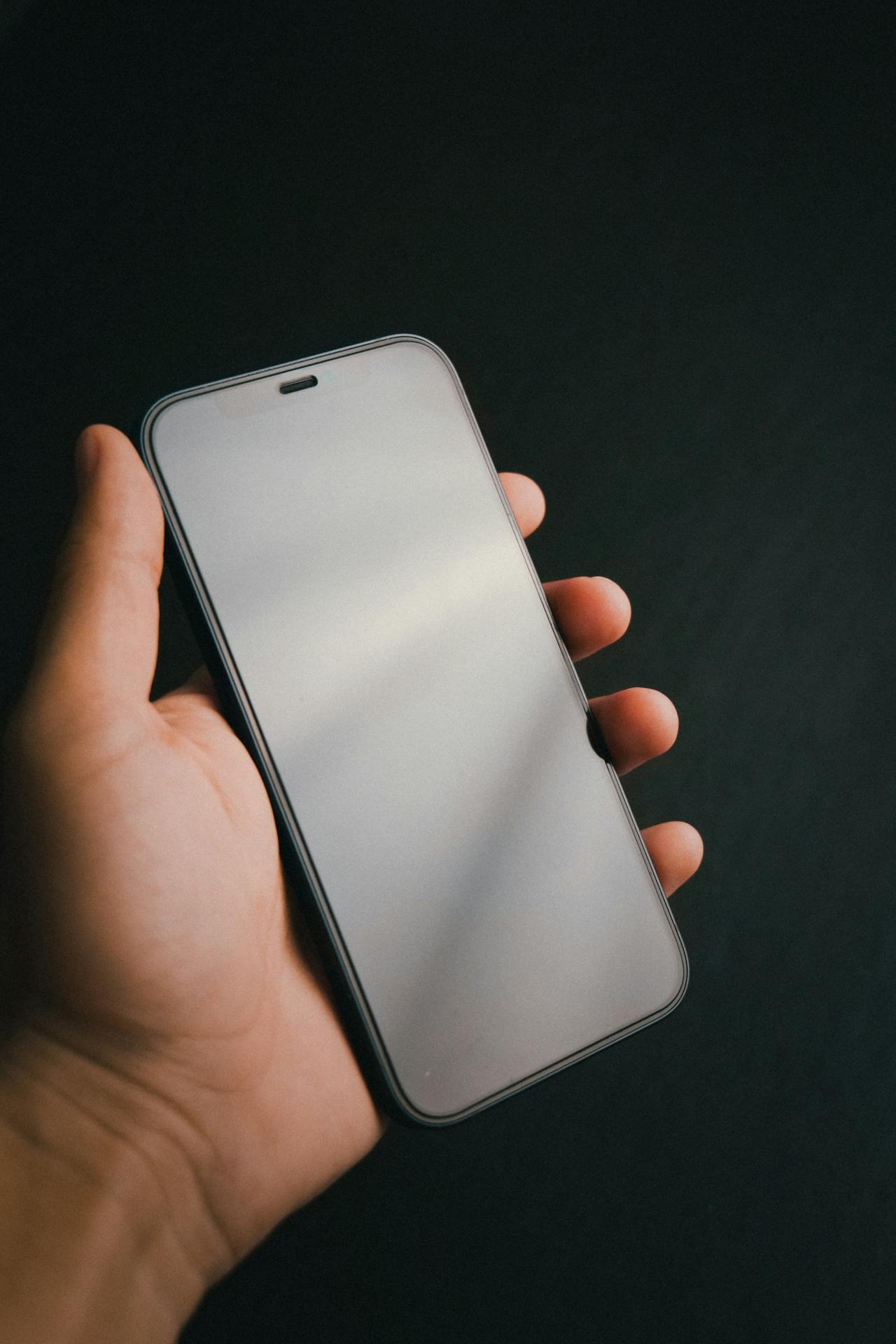 Un homme tenant son téléphone | Source : Pexels