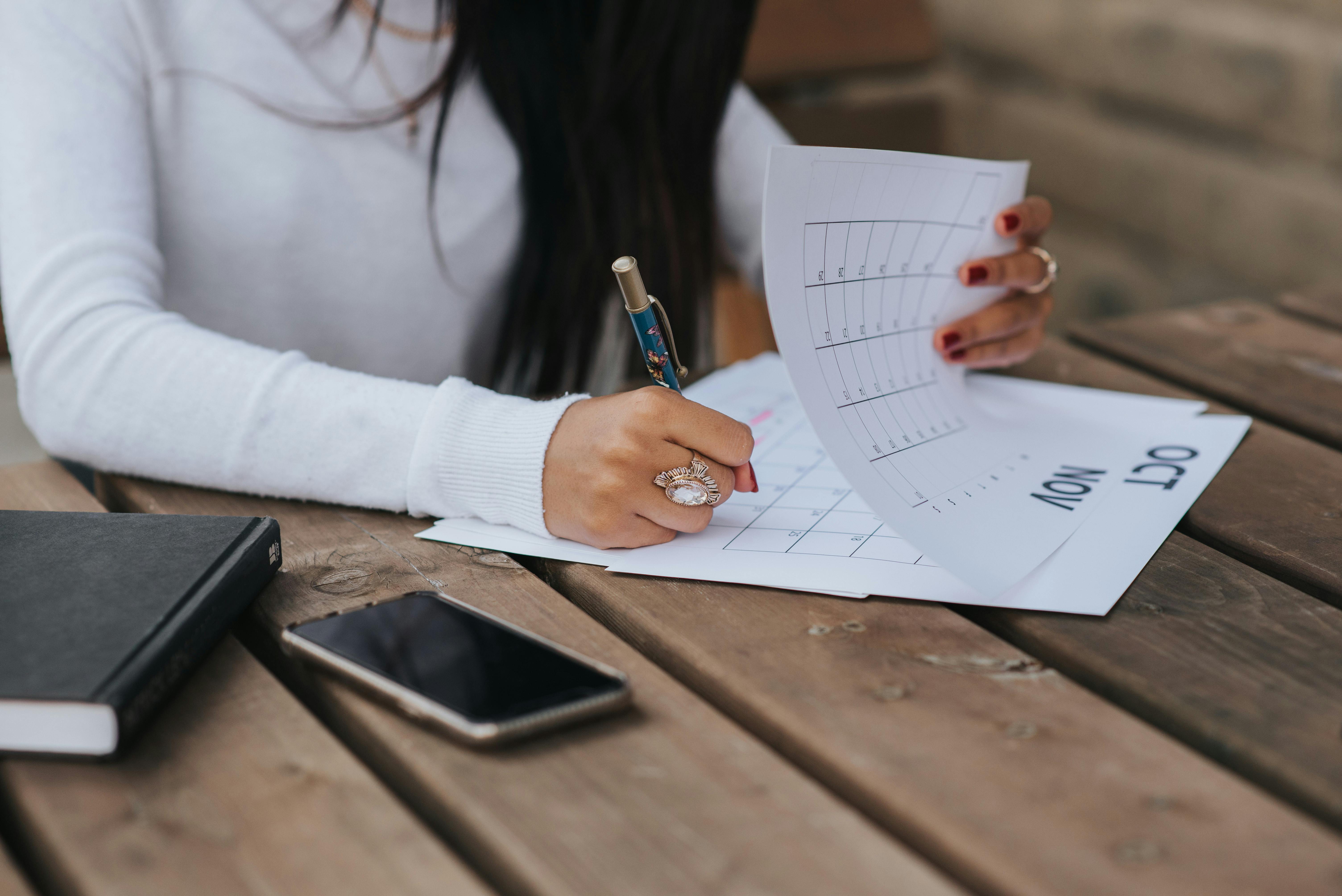 Une femme prend des notes sur un calendrier | Source : Pexels