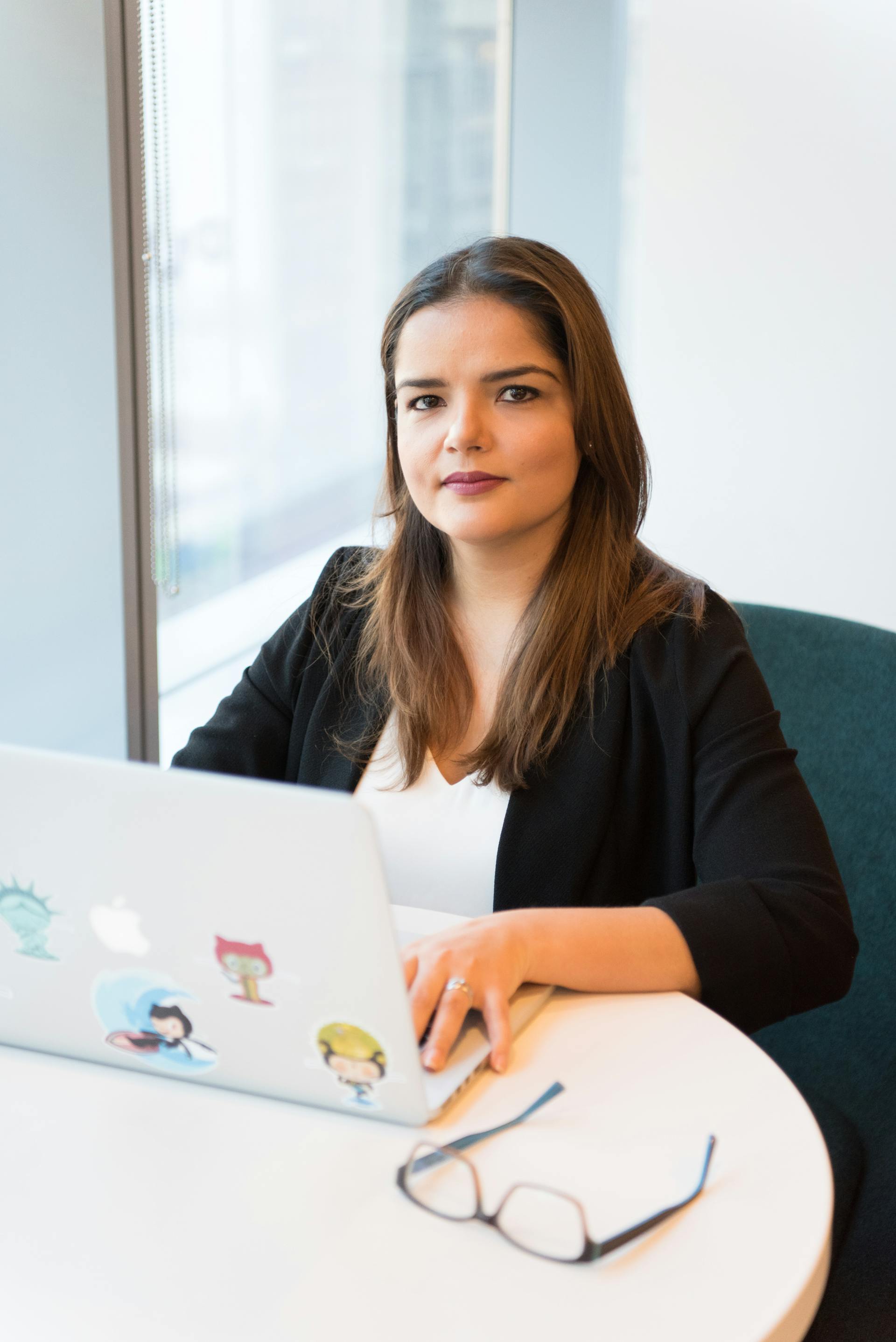 Une femme sérieuse assise devant un ordinateur portable | Source : Pexels