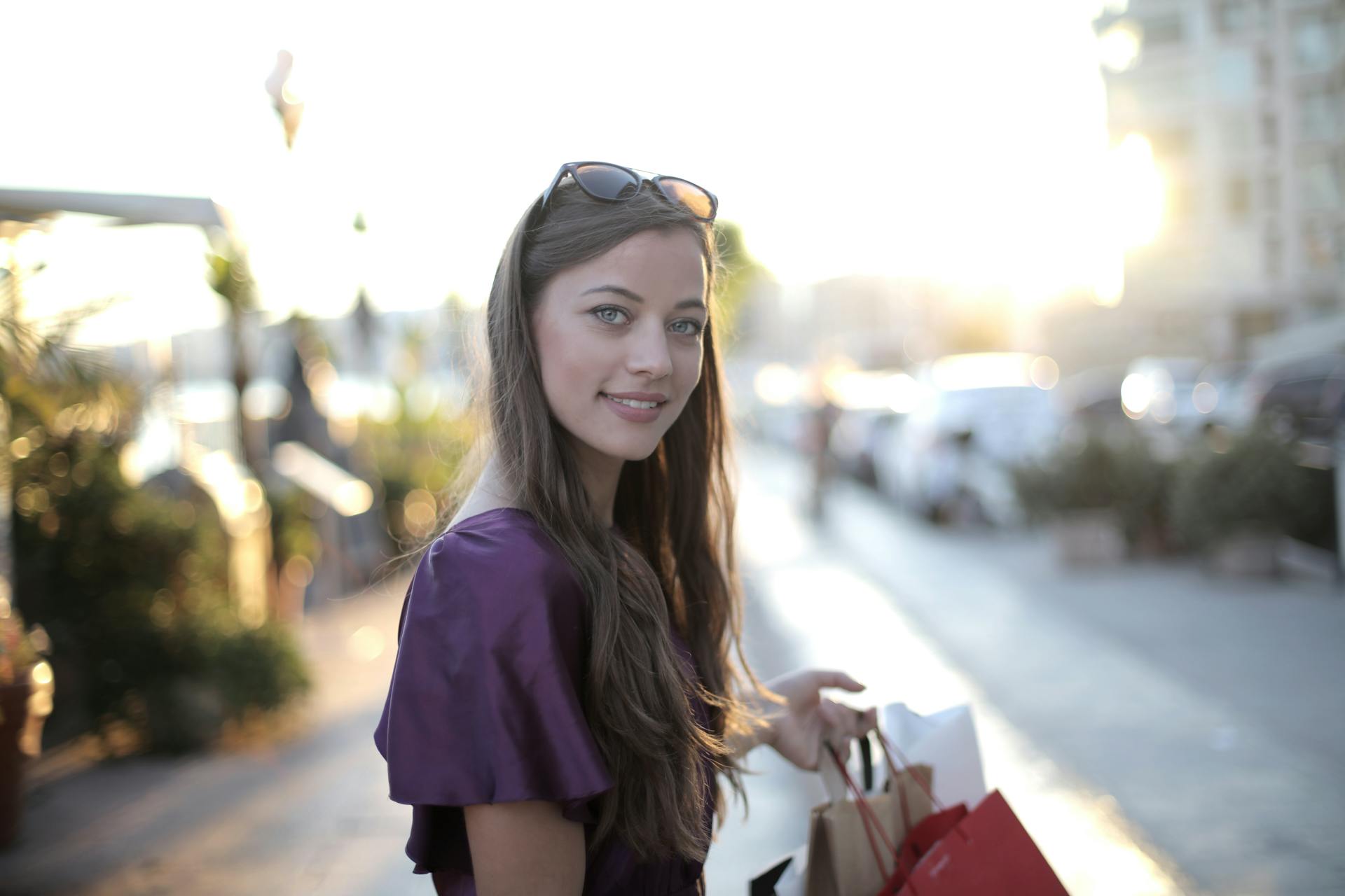 Une femme tenant des sacs de courses et souriant maladroitement à quelqu'un | Source : Pexels