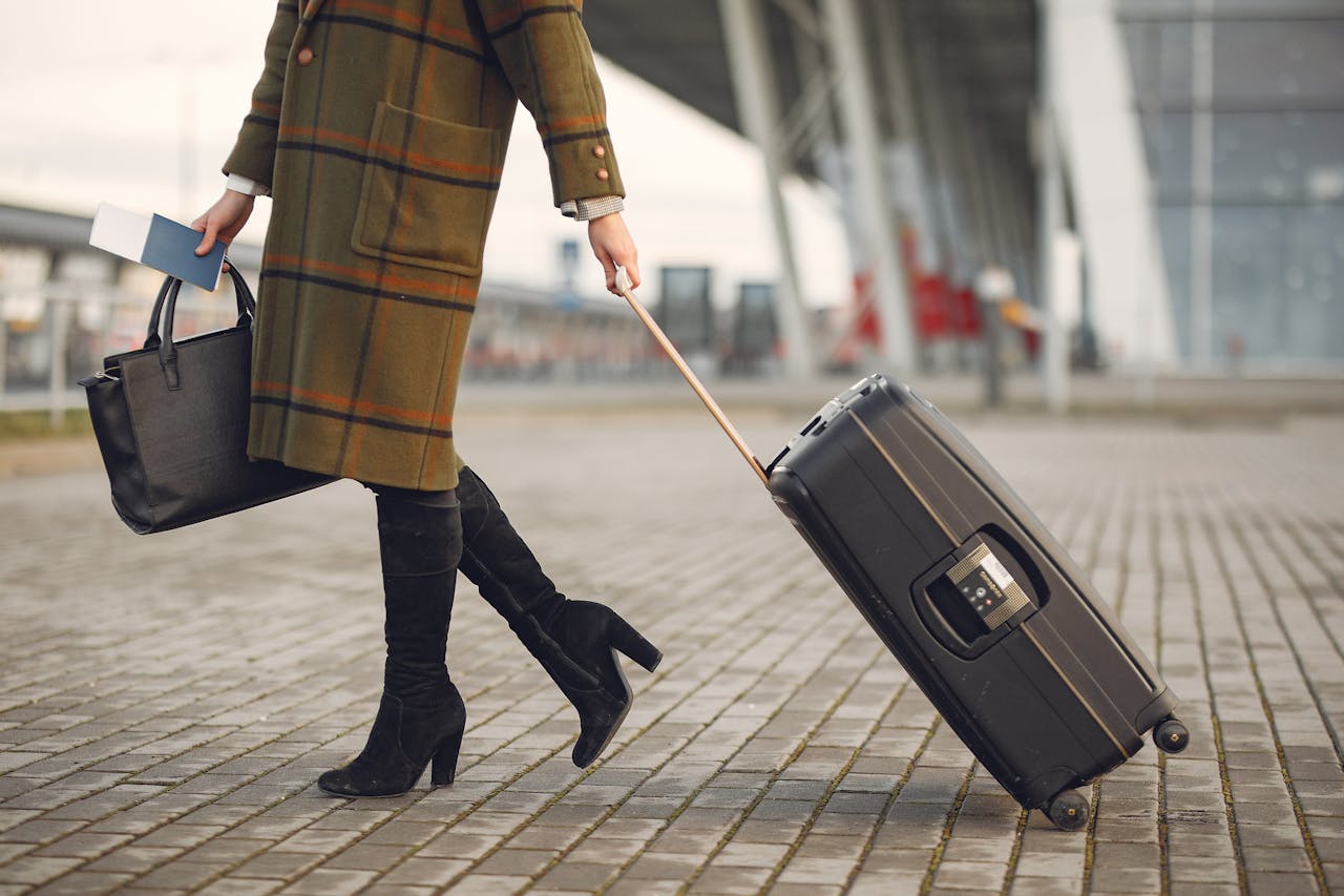 Une femme avec une valise et un sac | Source : Pexels