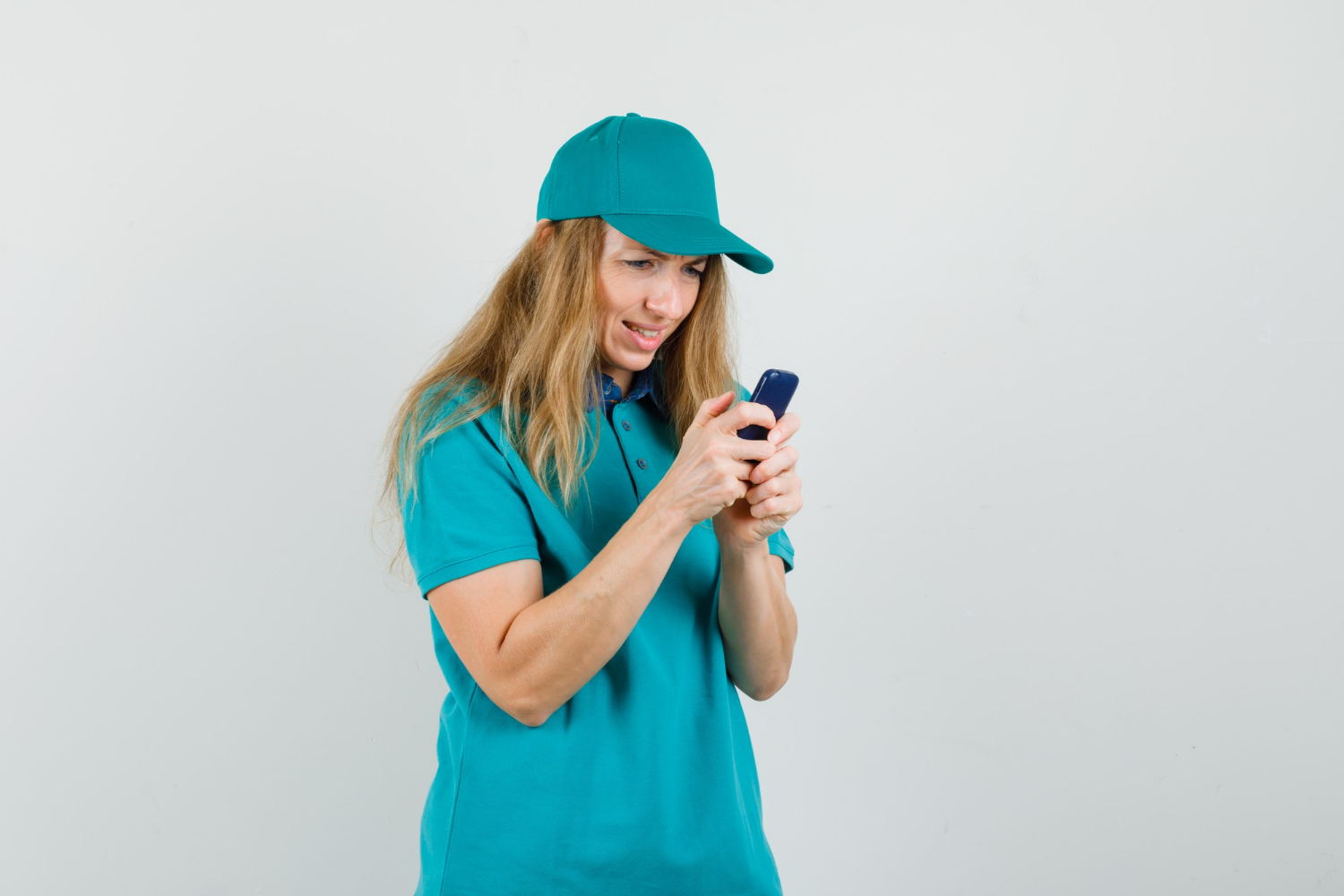 Une femme souriante envoyant des textos sur son téléphone | Source : Freepik