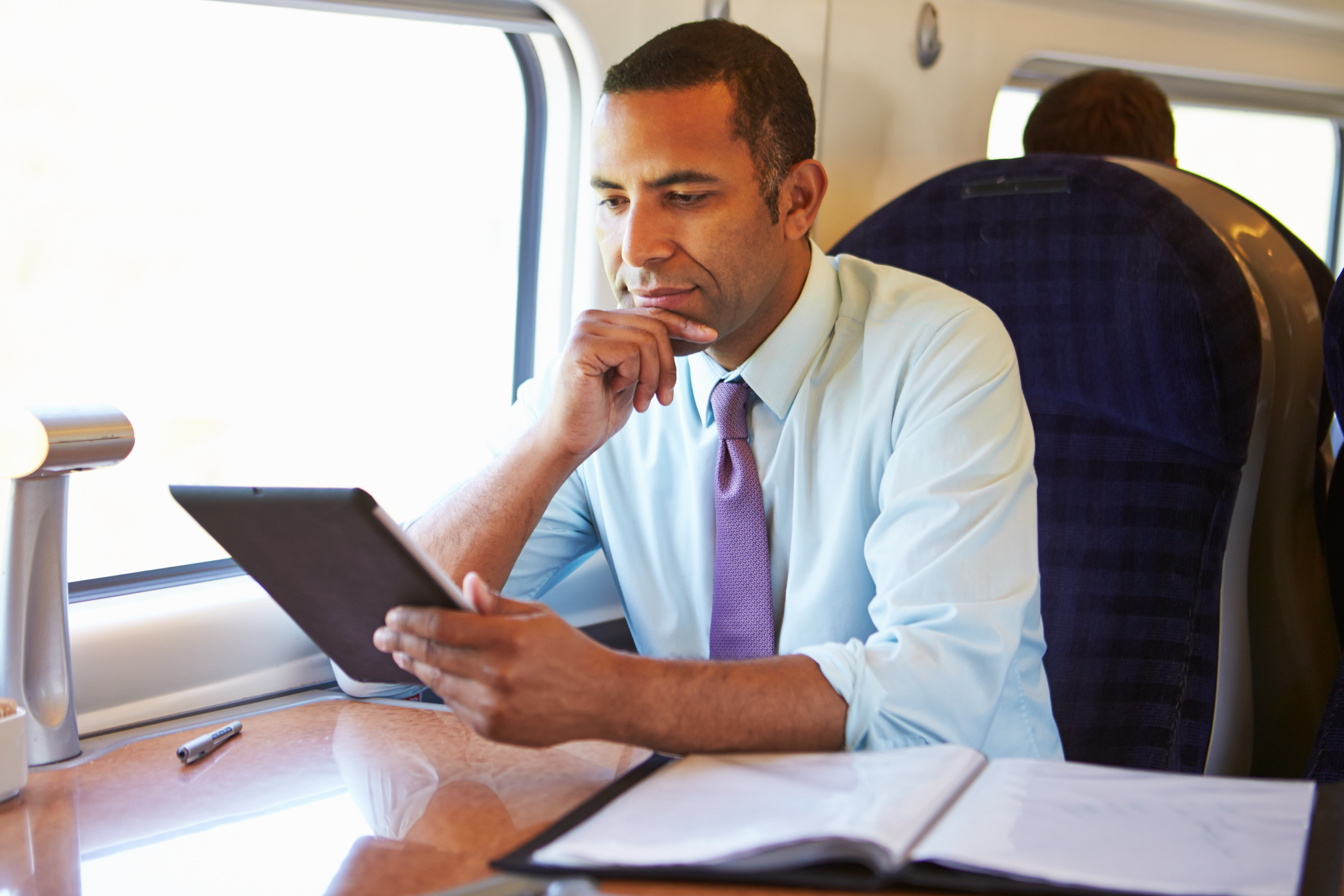 Un homme assis sur un siège côté fenêtre dans un train | Source : Shutterstock