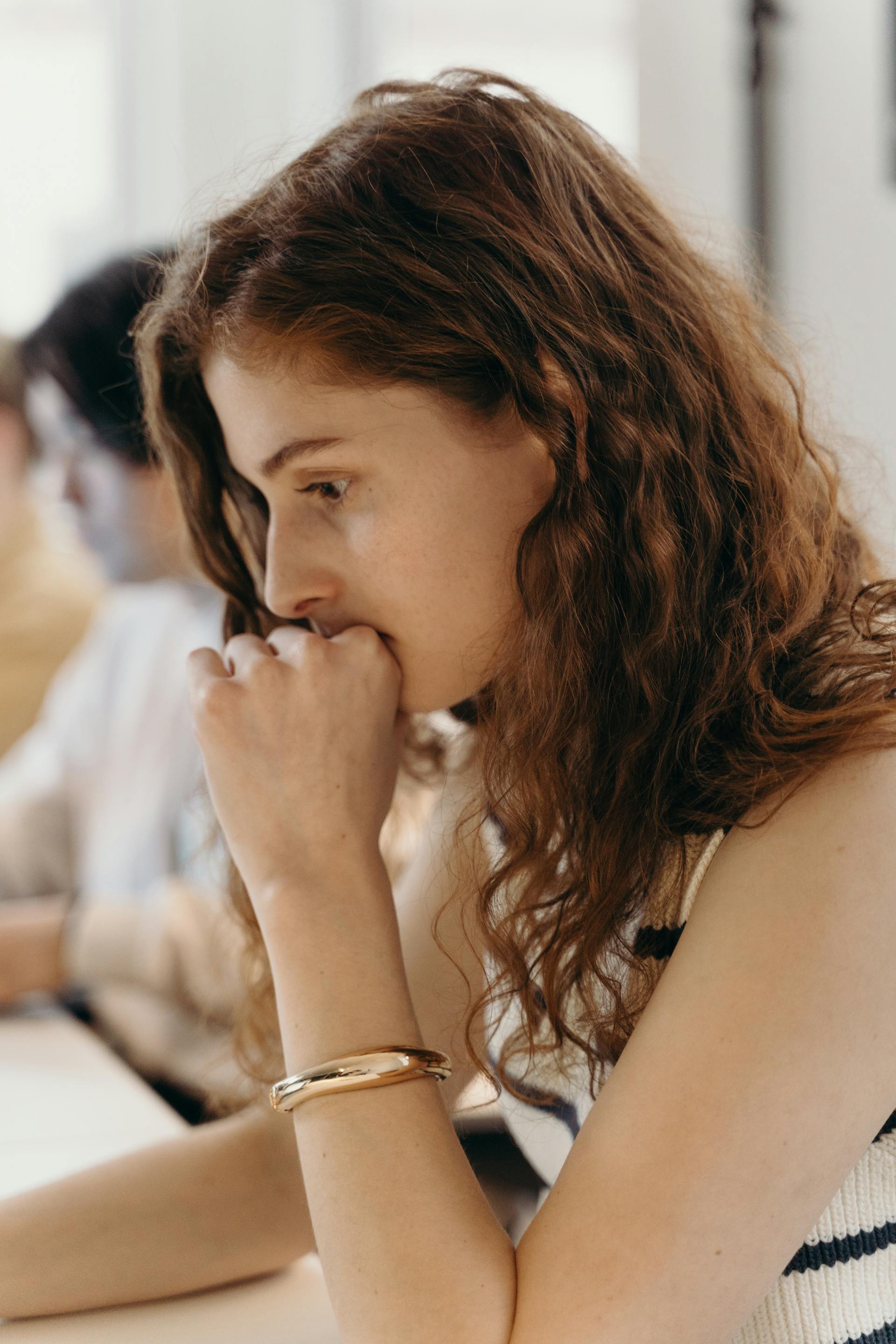 Une femme pensive assise à son bureau dans un bureau | Source : Pexels
