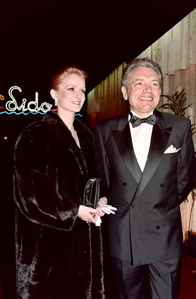 Le présentateur de télévision français Jacques Martin et son épouse Céline Boisson assistent à la nouvelle revue du cabaret du Lido à Paris, le 14 mars 1990. | Photo : Getty Images