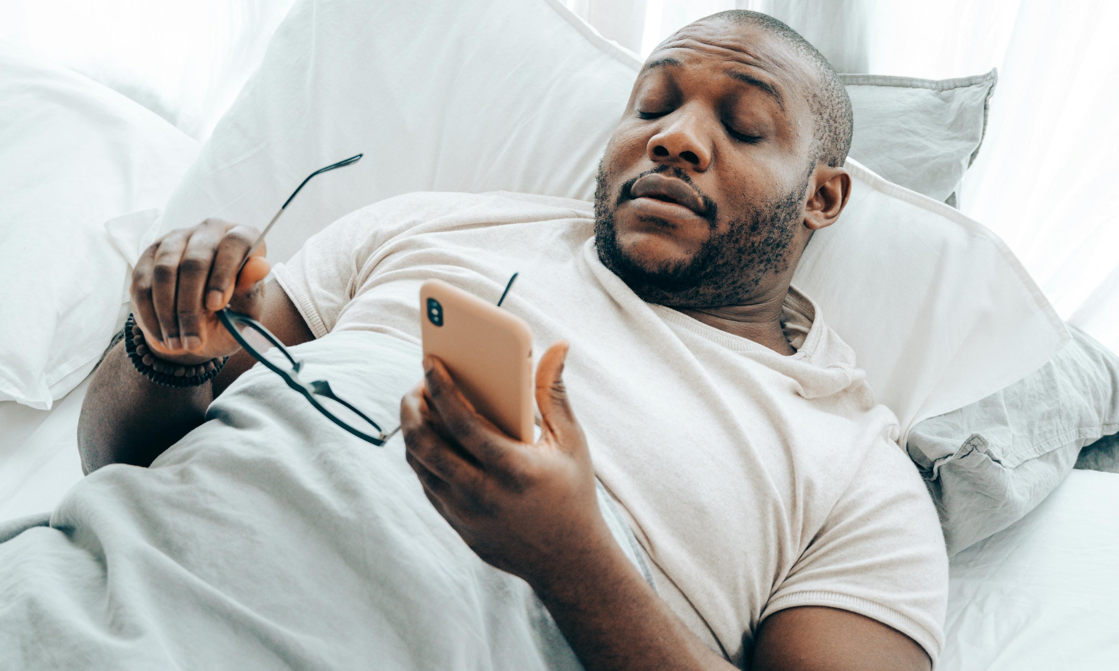 Un homme à l'air fatigué tenant un téléphone portable | Source : Pexels