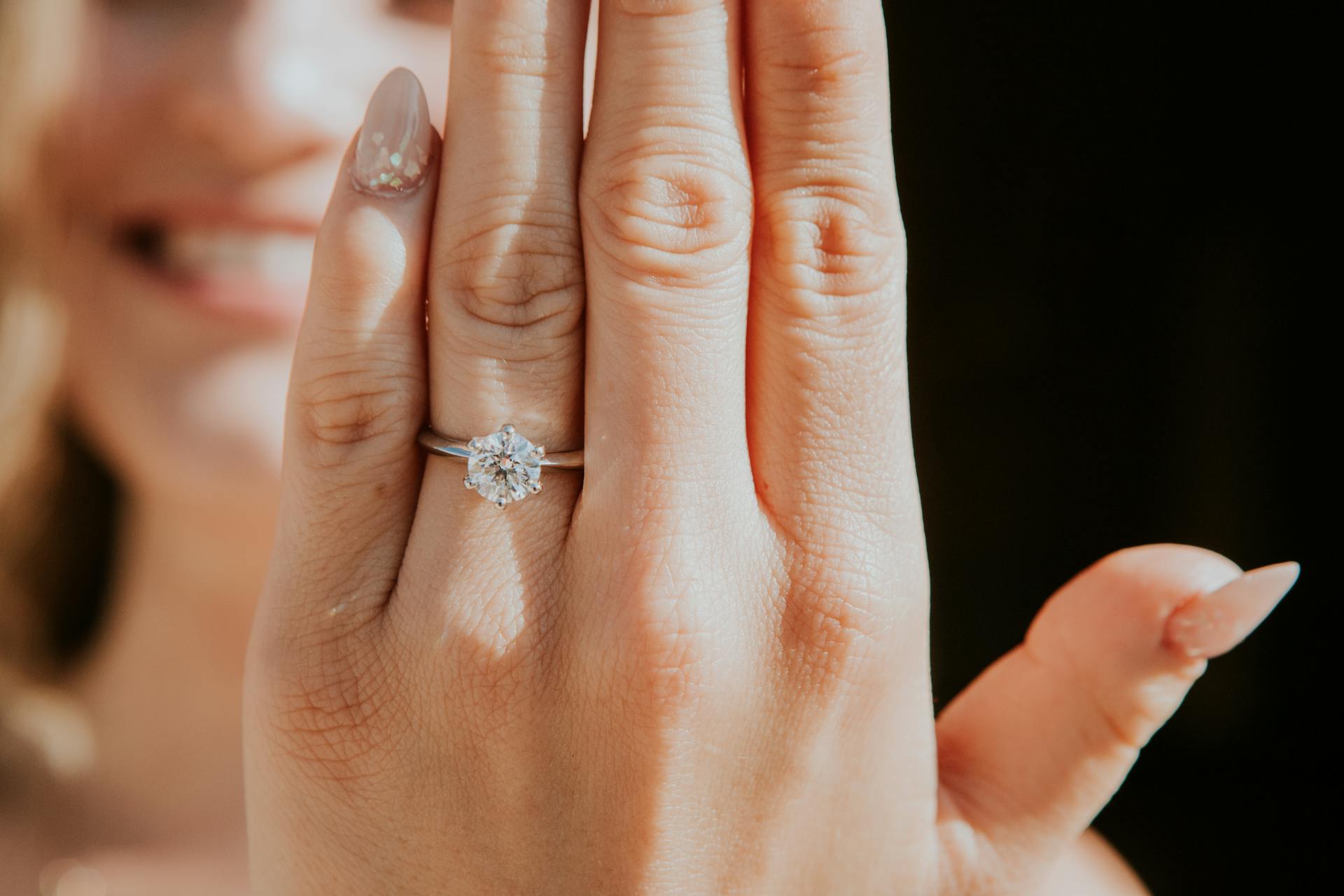 Une femme exhibant une bague en diamant à son doigt | Source : Pexels