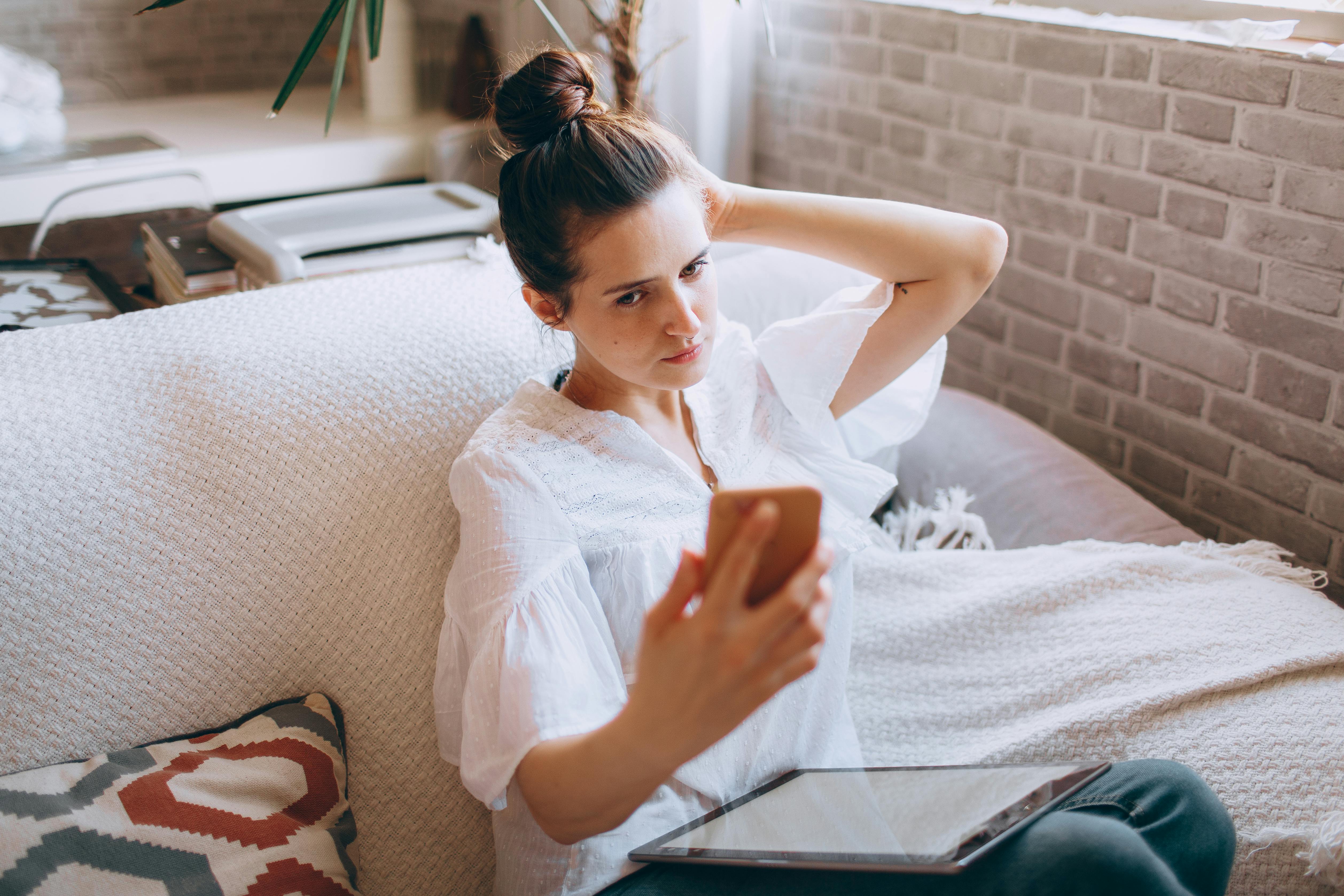 Une femme agacée qui regarde son téléphone | Source : Pexels