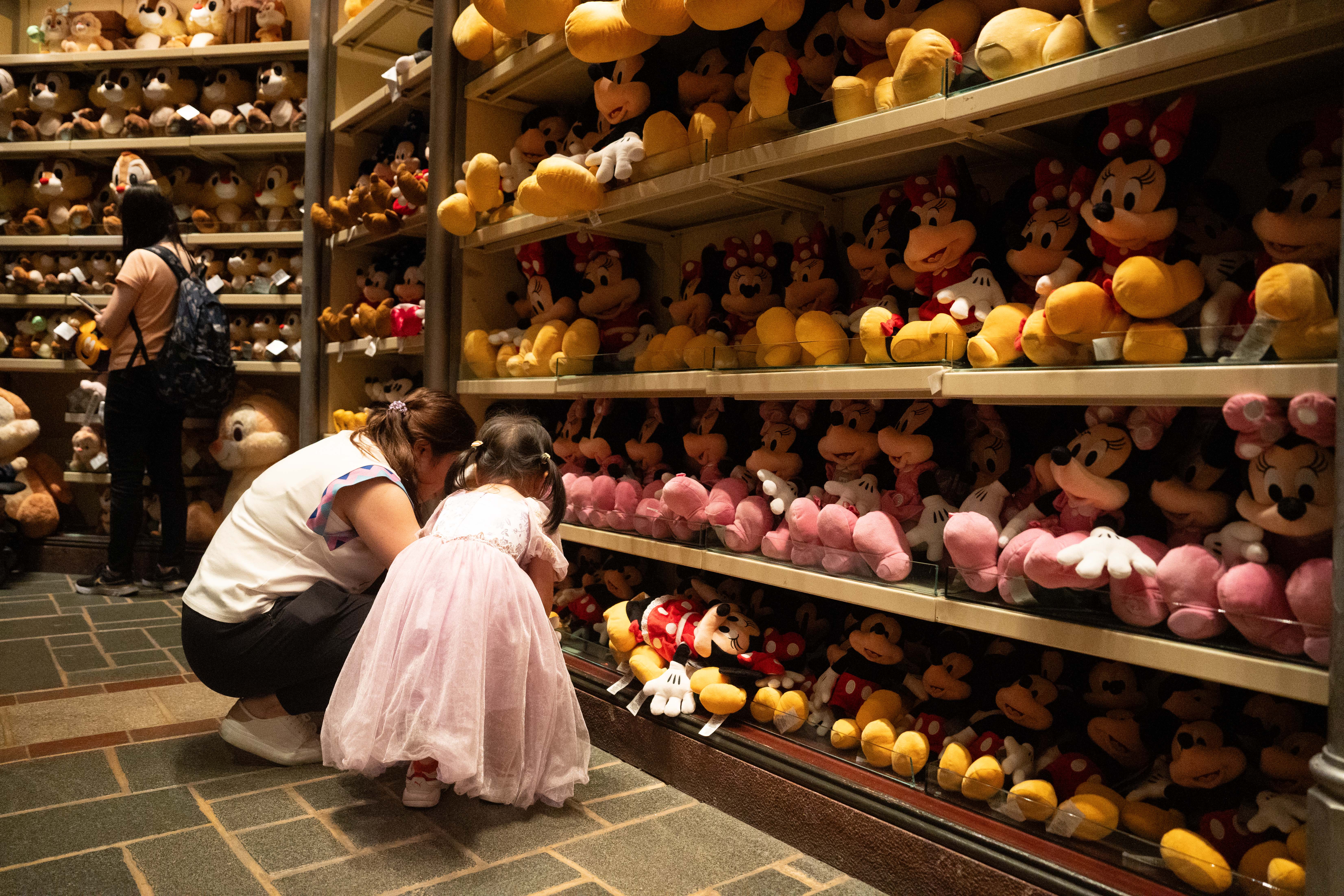 Une fille et une femme plus âgée dans un magasin Disney avec des jouets en peluche | Source : Getty Images