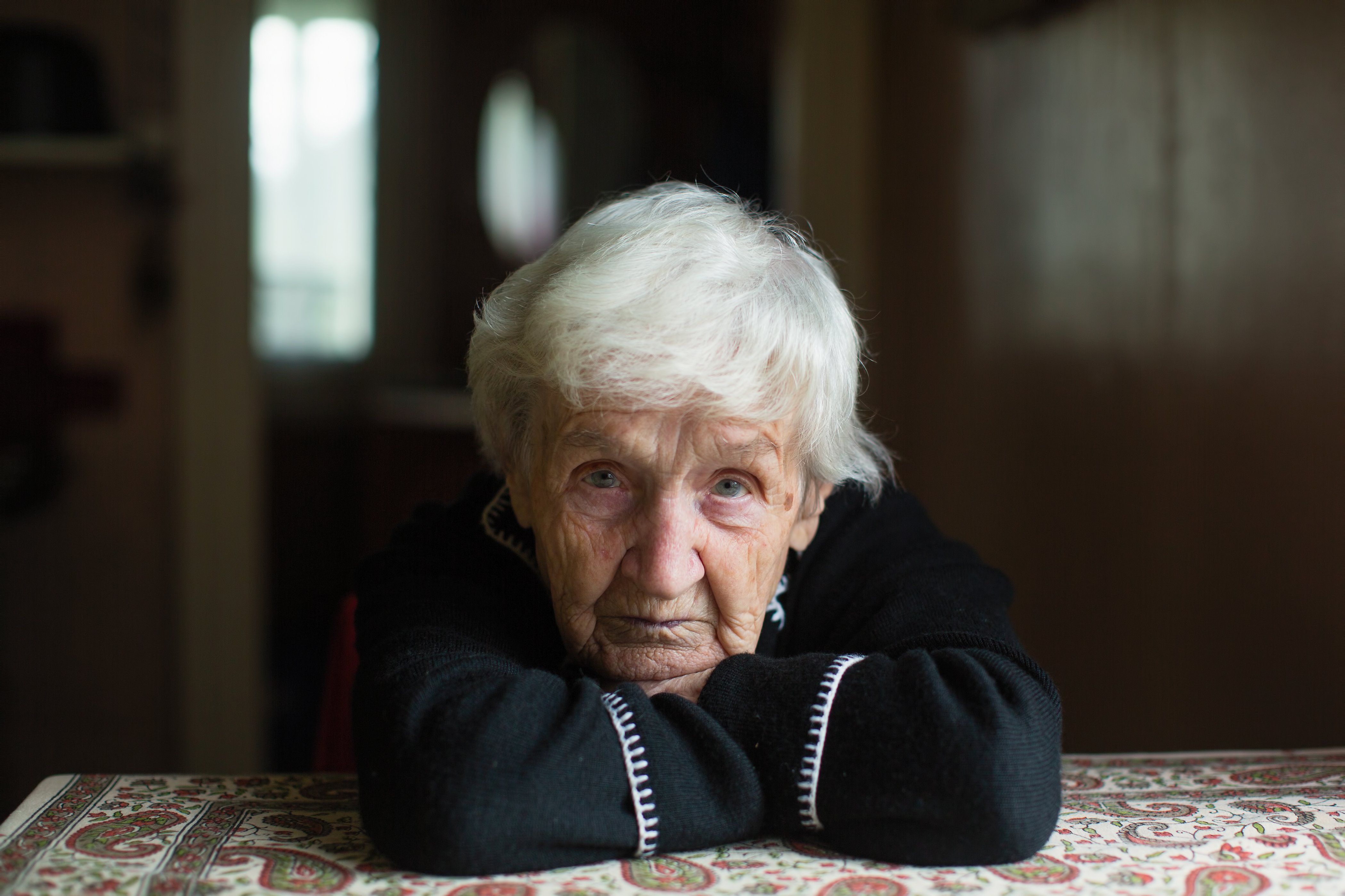 Portrait d'une femme âgée assise chez elle | Source : Shutterstock