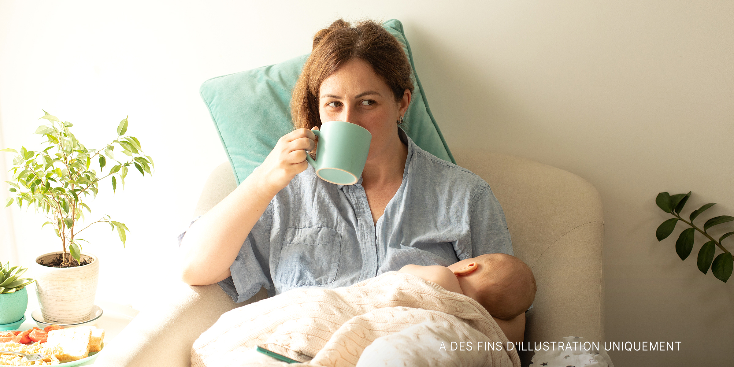 Une femme qui allaite son nouveau-né tout en buvant du thé | Source : Shutterstock