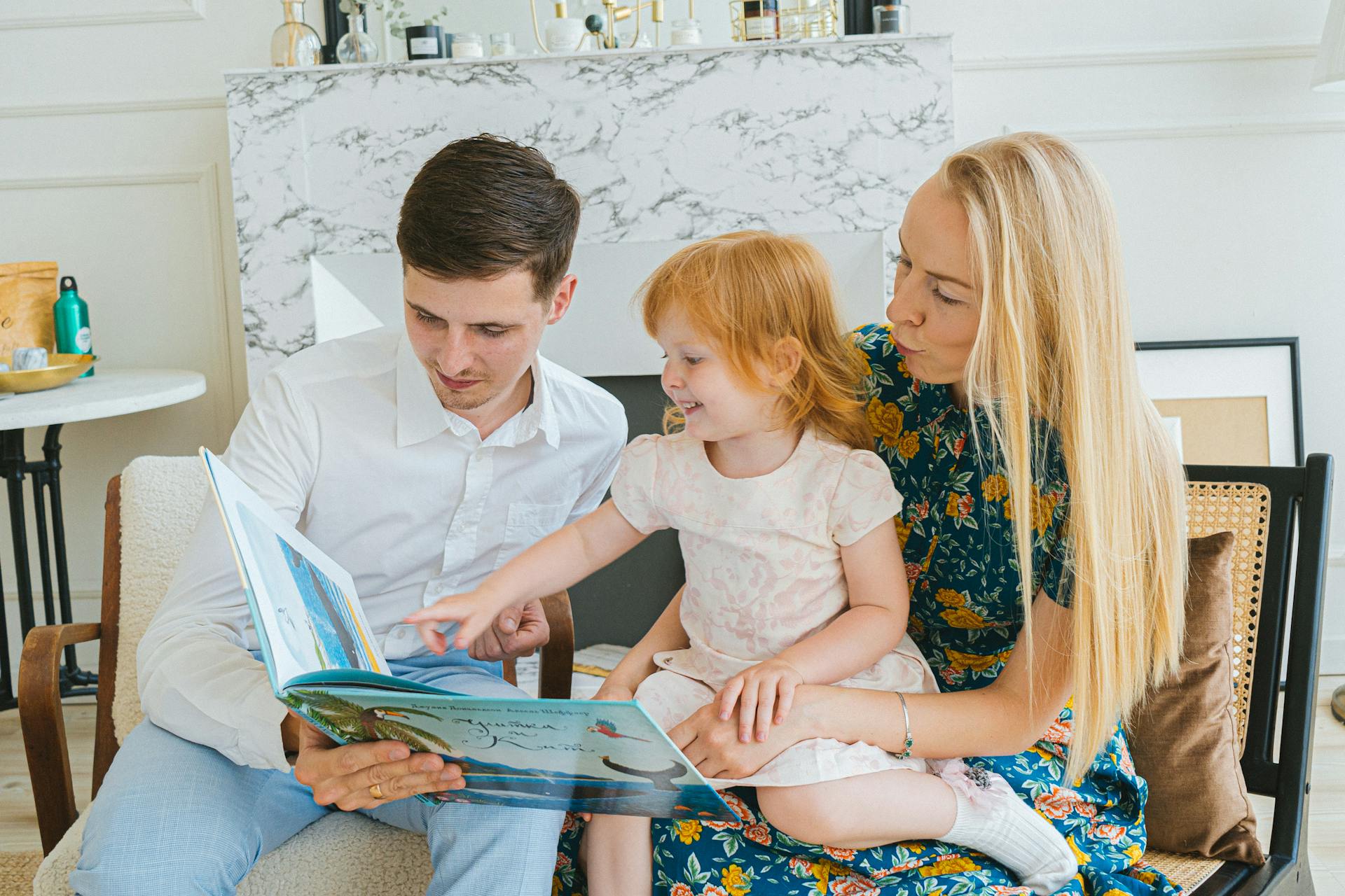 Des parents lisent un livre à leur petite fille | Source : Pexels