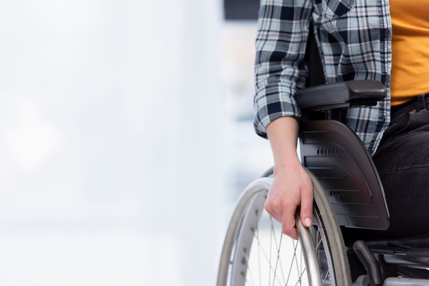 Photo recadrée d'une femme assise sur son fauteuil roulant | Source : Freepik