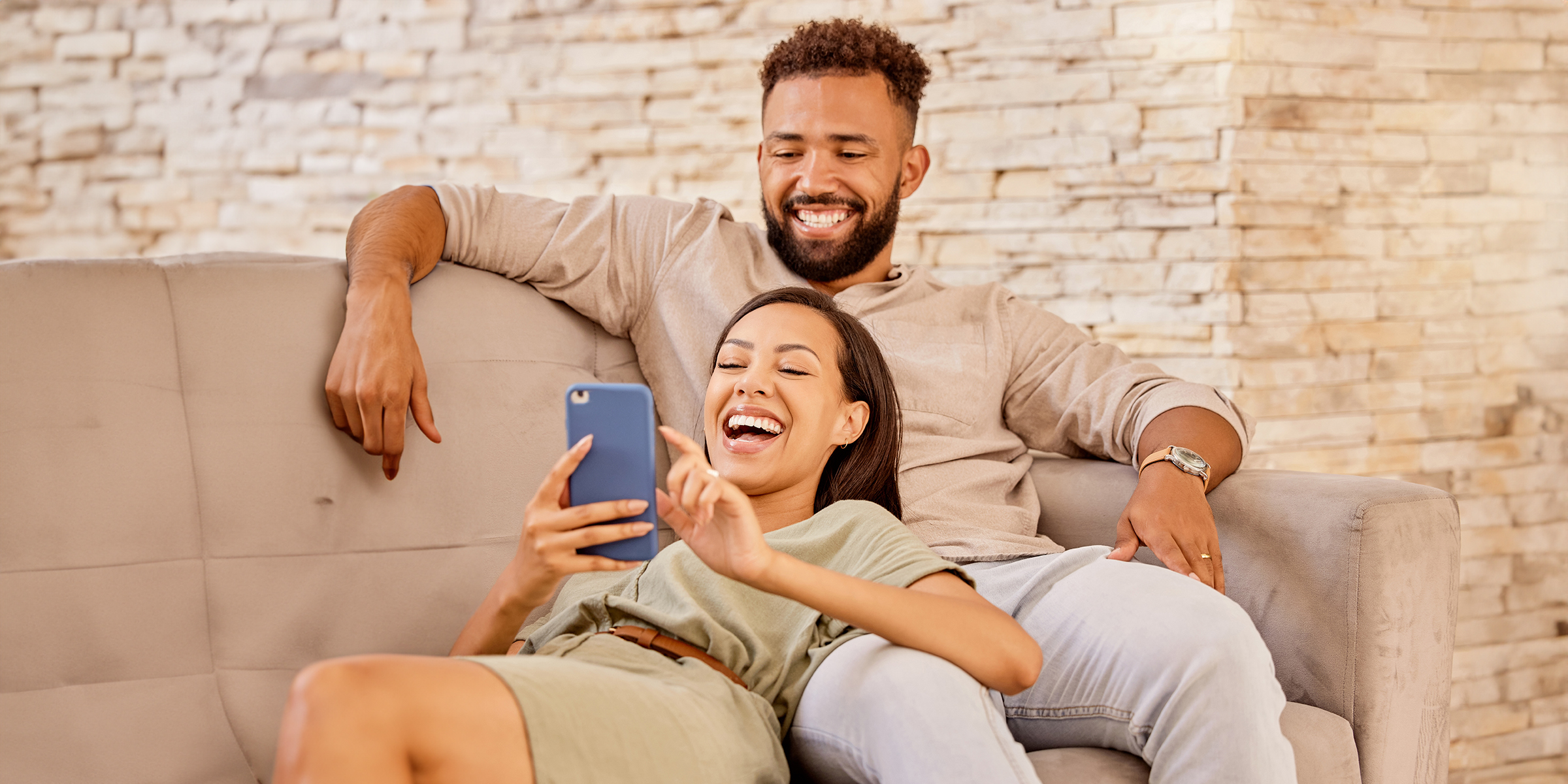 Un couple qui rit en regardant l'écran d'un téléphone | Source : Shutterstock