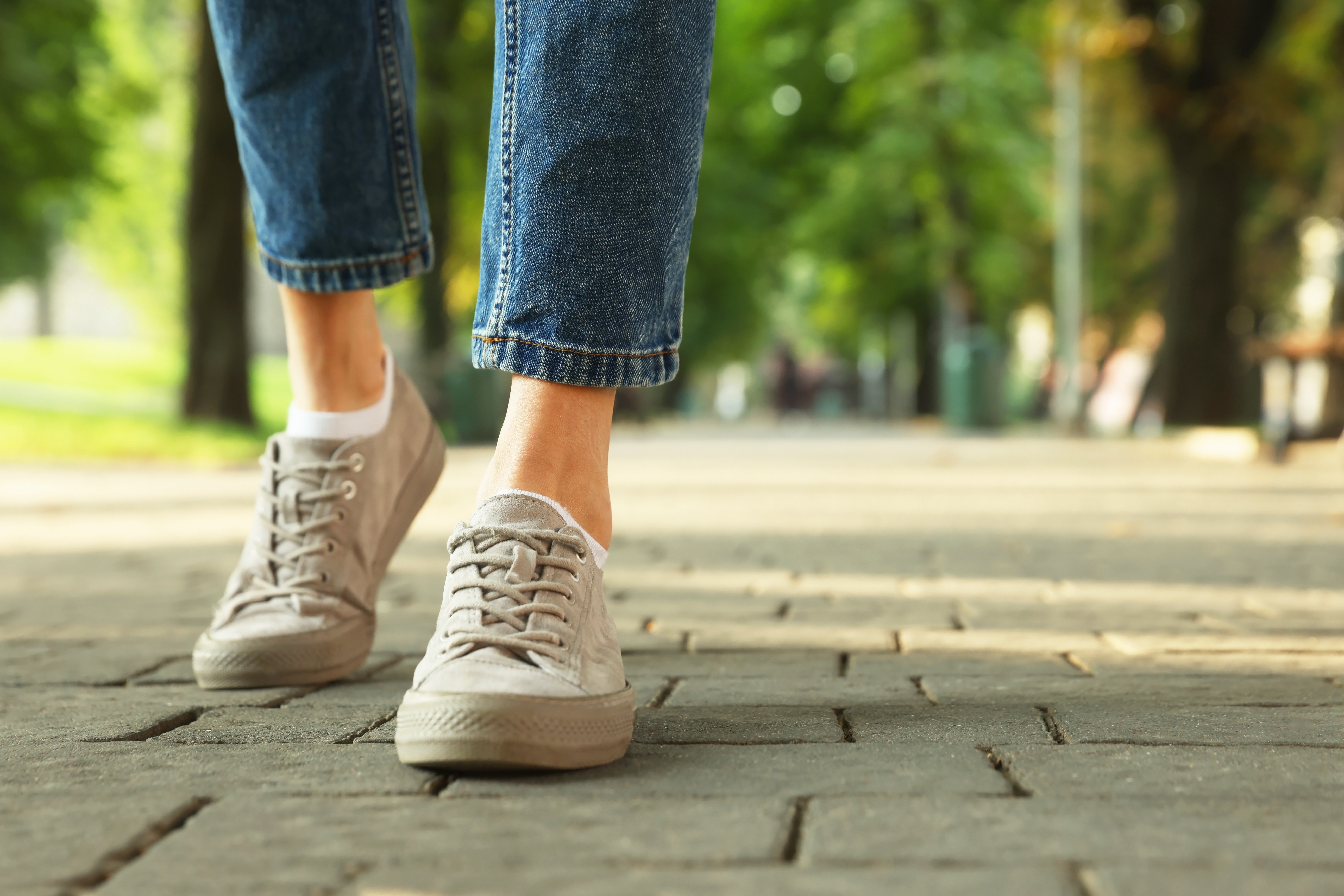 Mujer en zapatillas de deporte caminando por la calle de la ciudad. | Fuente: Shutterstock