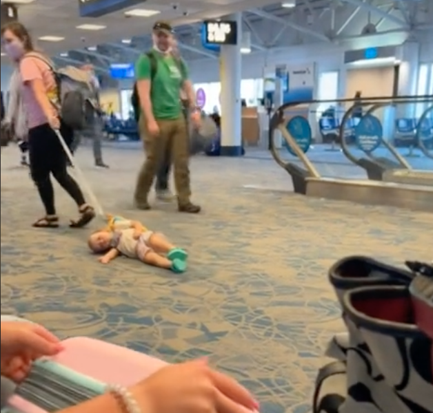Une femme traînant un enfant à l'aéroport. | Source : tiktok.com/cacadoodledoo83