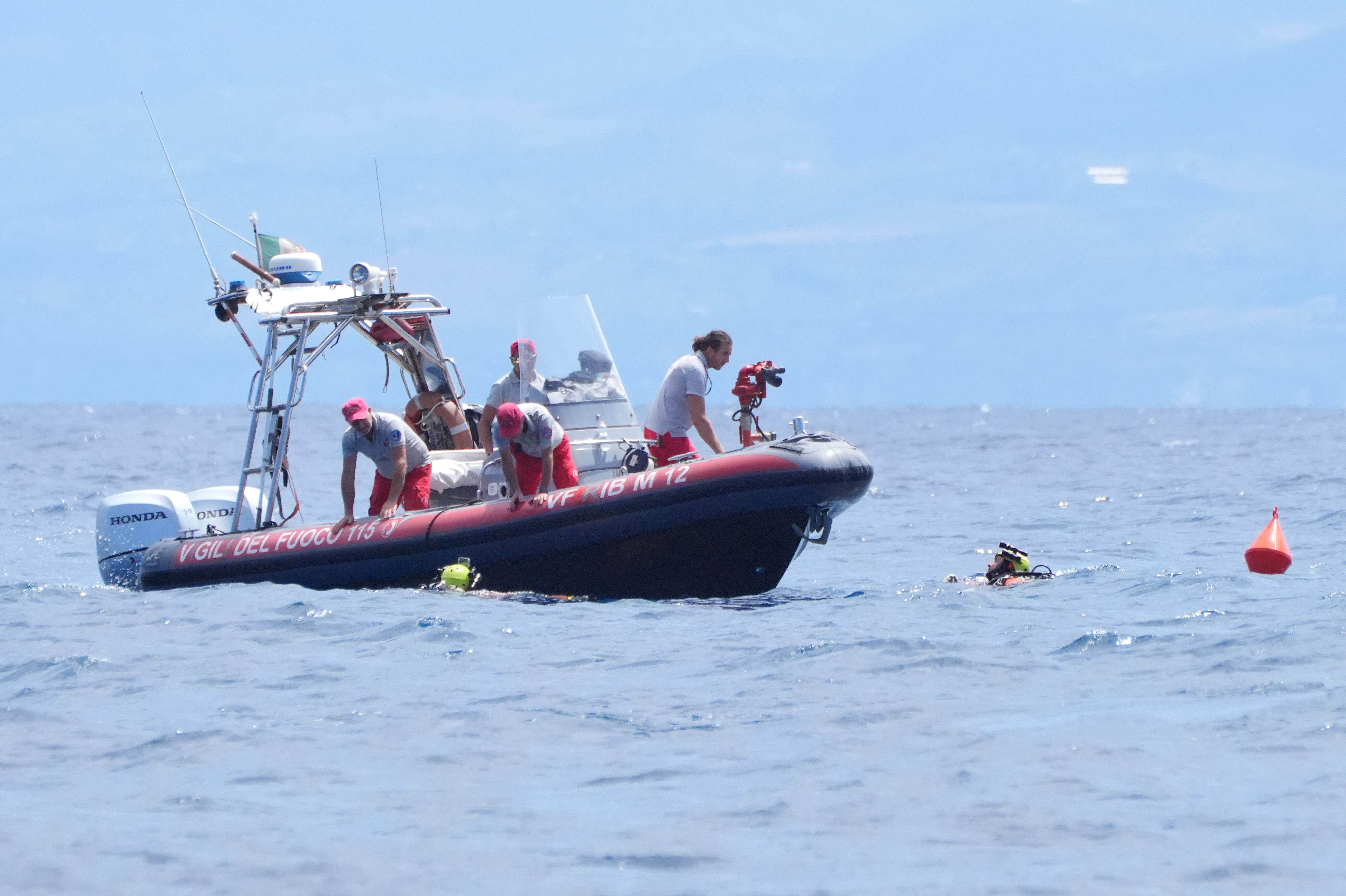 Une équipe de plongeurs des pompiers italiens fait surface à leur bateau pneumatique rigide (RiB) depuis le site de plongée au large de Porticello, en Sicile, le 21 août 2024 | Source : Getty Images