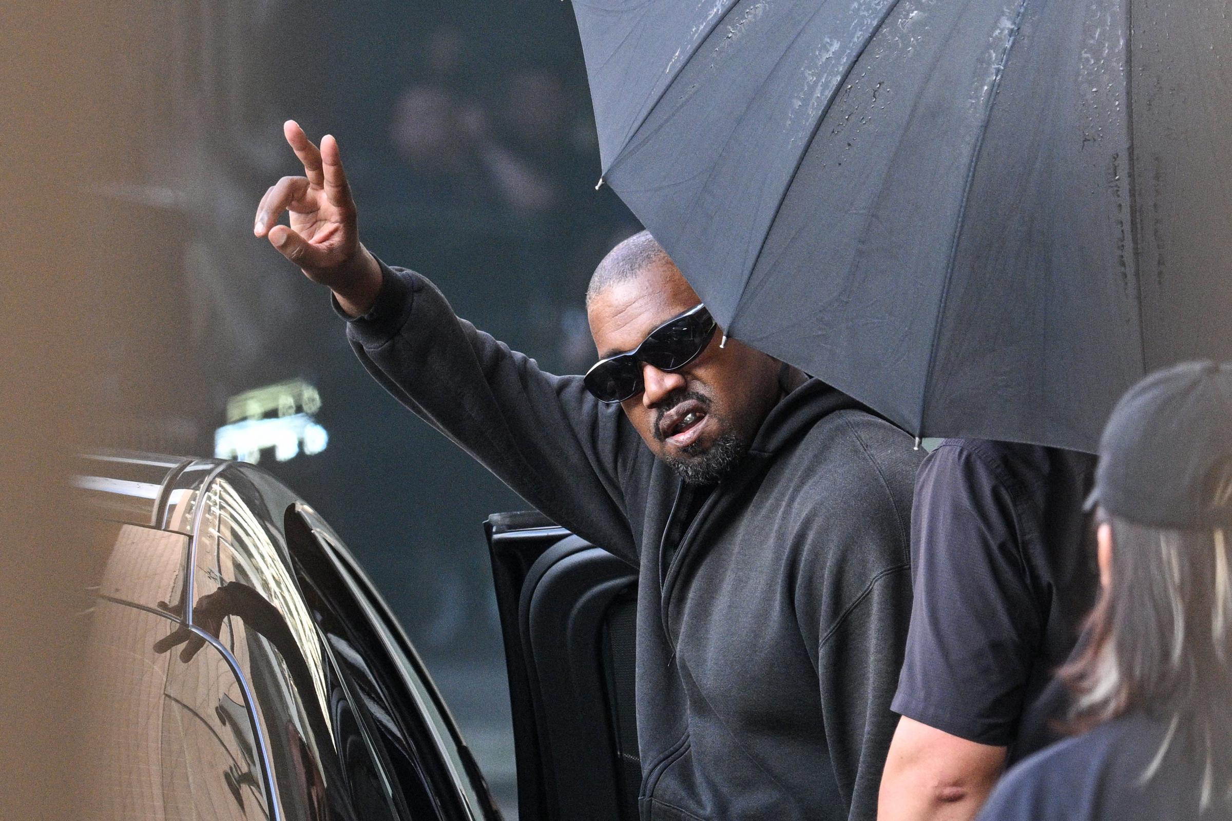 Kanye West fait un geste à son arrivée à l'aéroport international de Shanghai Pudong, le 11 juillet 2025. | Source : Getty Images
