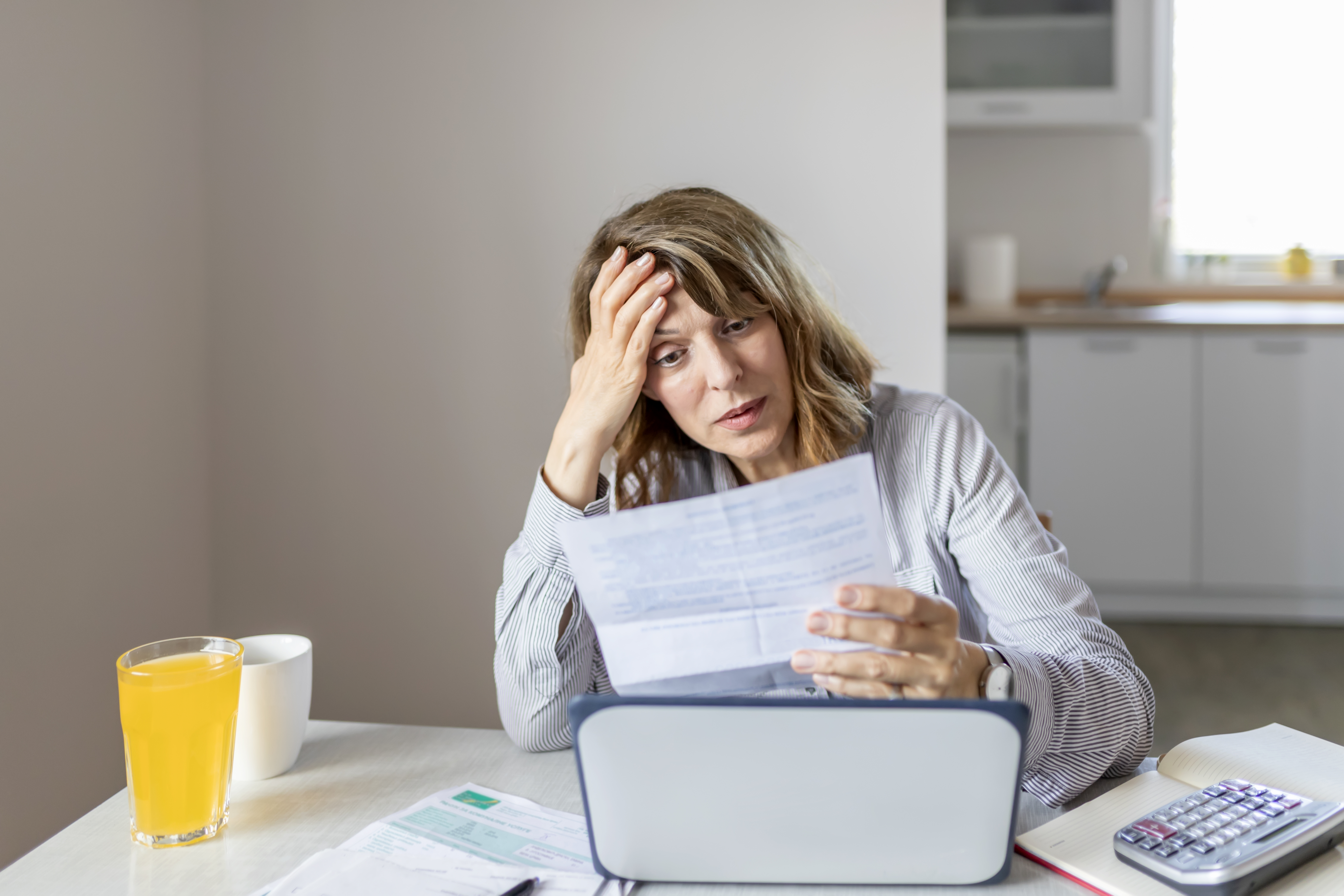 Femme âgée calculant ses dépenses domestiques | Source : Getty Images