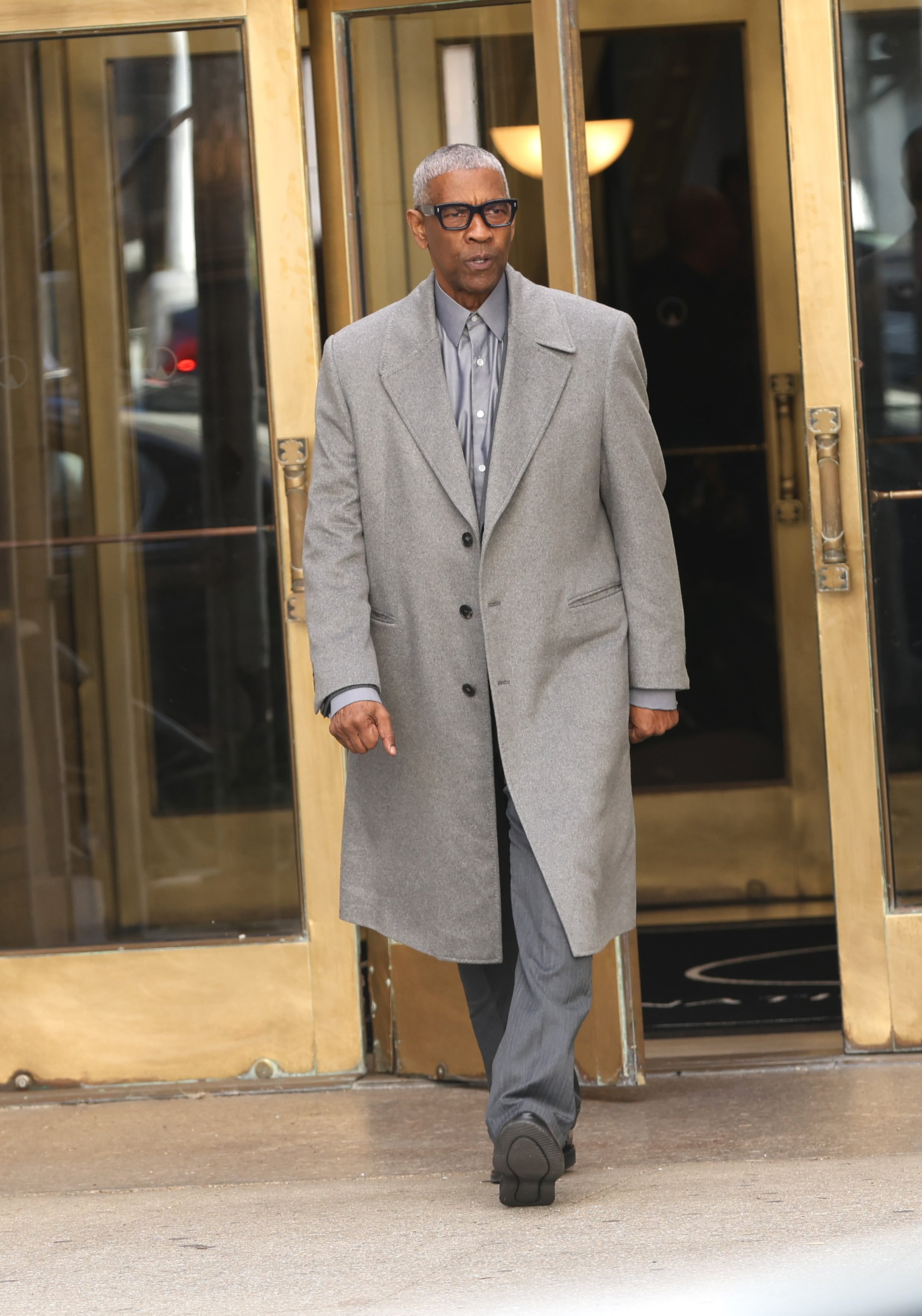 Denzel Washington fait une apparition à Newark pendant le tournage de « Here Comes the Flood ». Avec ses cheveux gris élégants, ses lunettes oversize et son manteau gris impeccable, son look mature a immédiatement séduit les fans alors qu'il se promenait avec assurance sur le plateau.