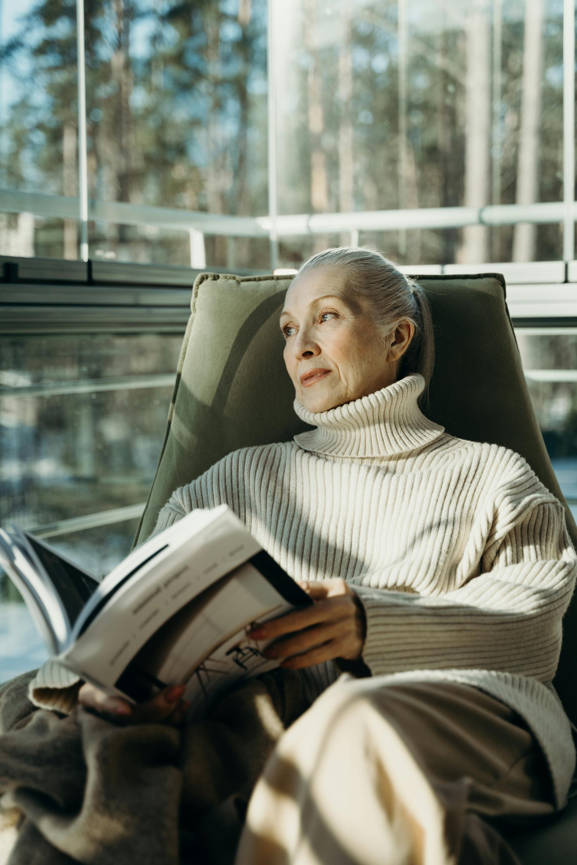 Une vieille femme assise avec un magazine | Source : Pexels