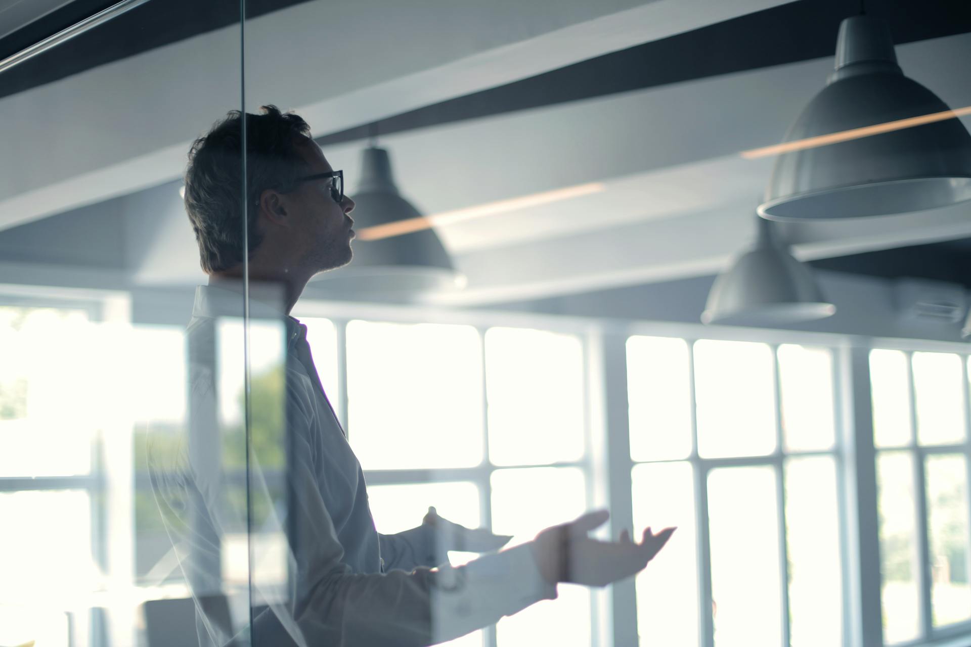 Homme parlant derrière un panneau de verre | Source : Pexels