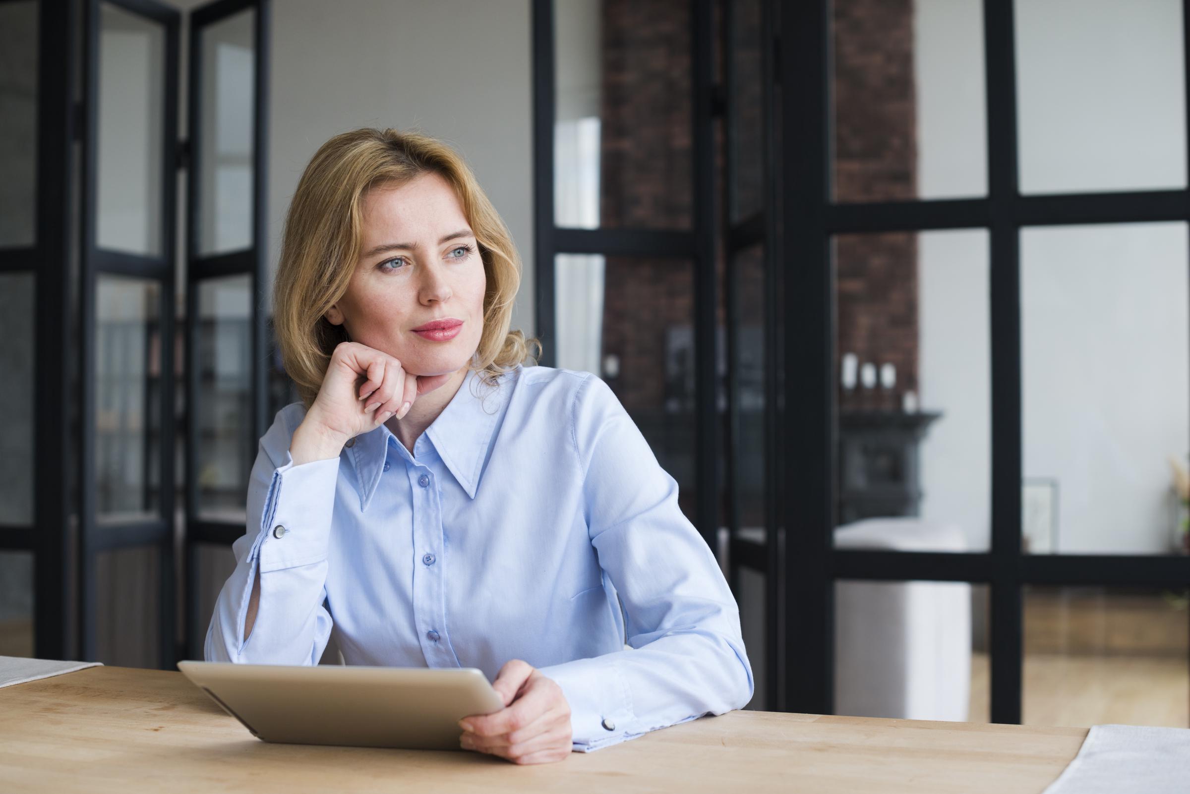 Une femme assise à une table | Source : Freepik