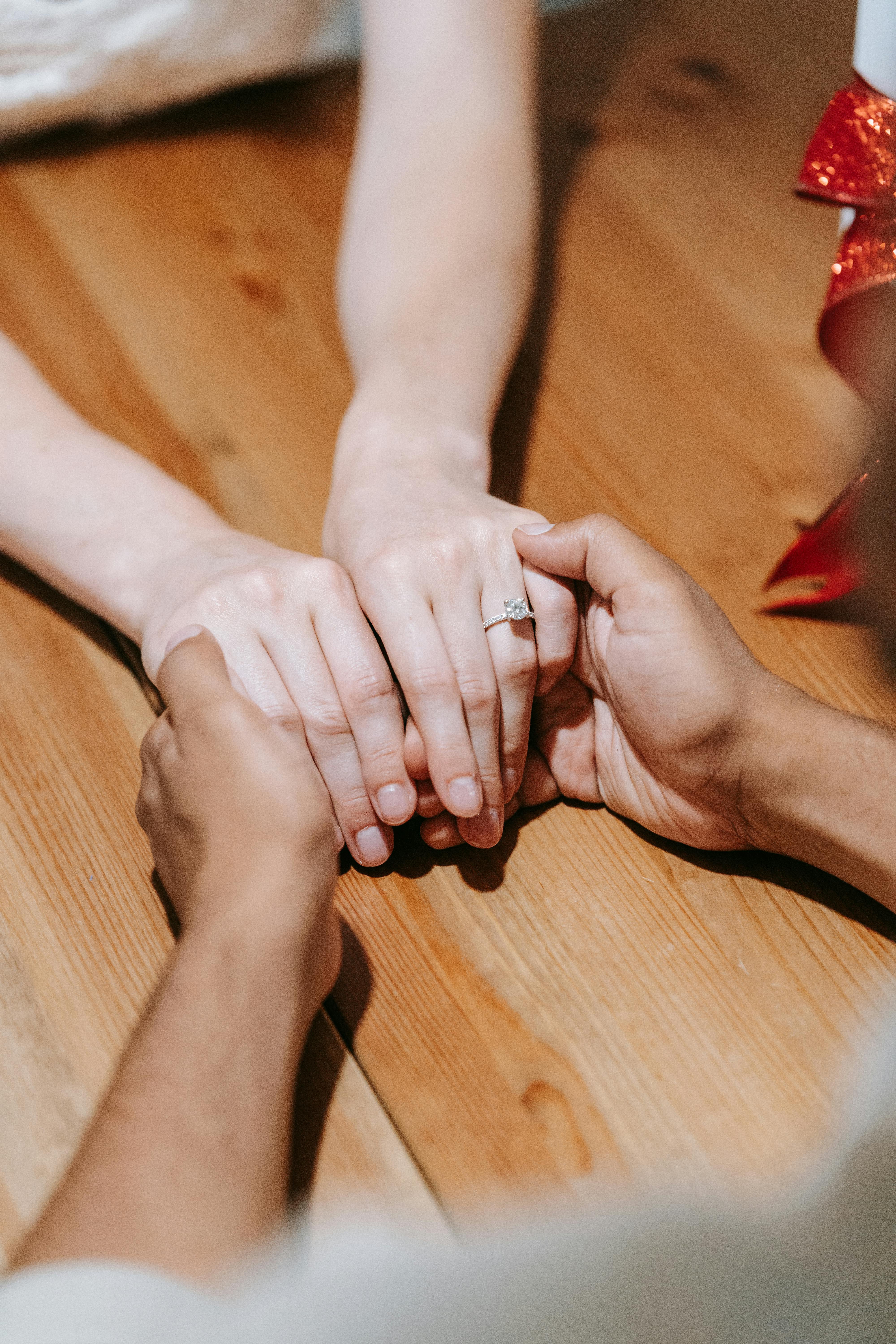 Un couple se tenant par la main sur une table | Source : Pexels