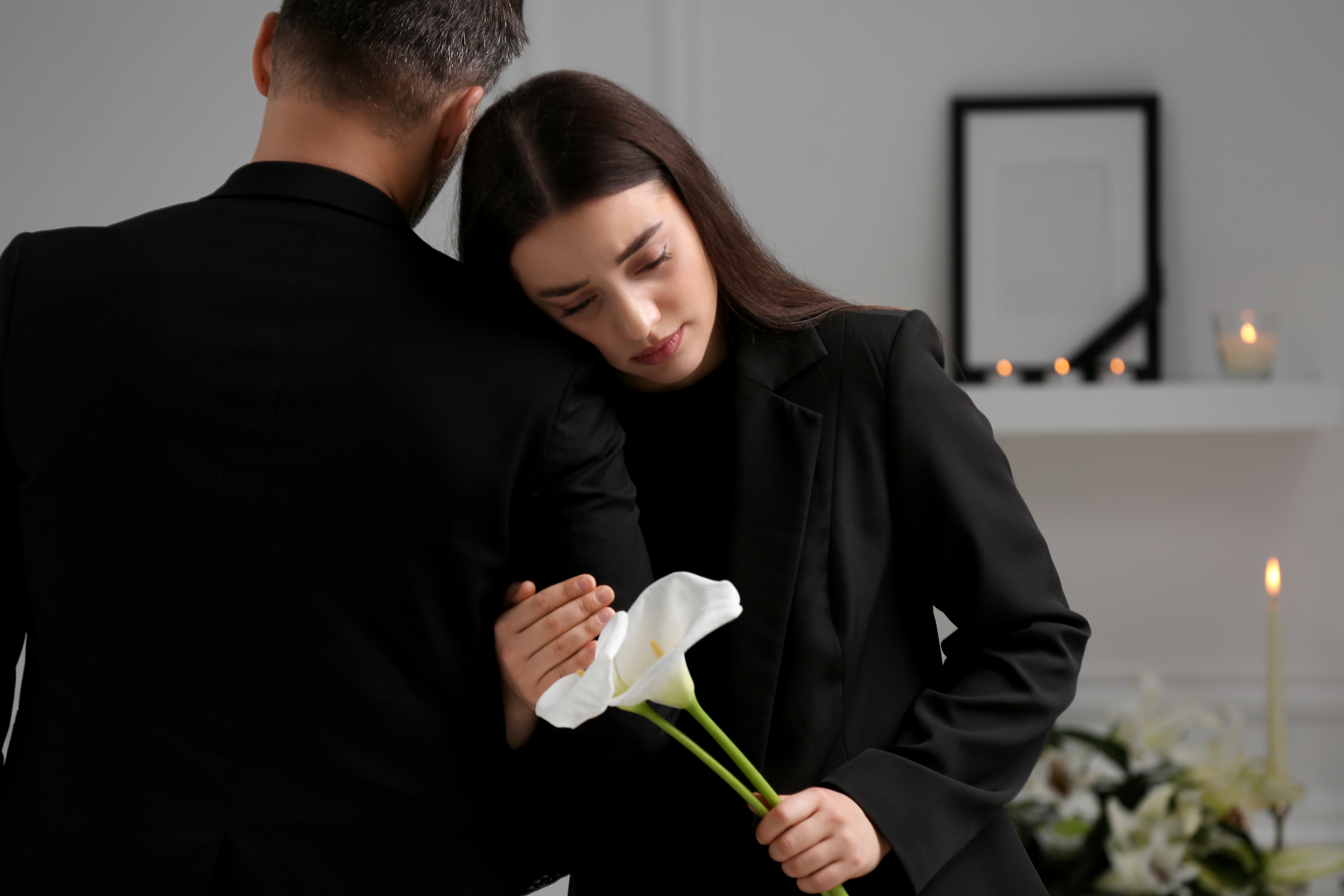 Un couple à l'air triste lors d'un enterrement | Source : Shuttertsock