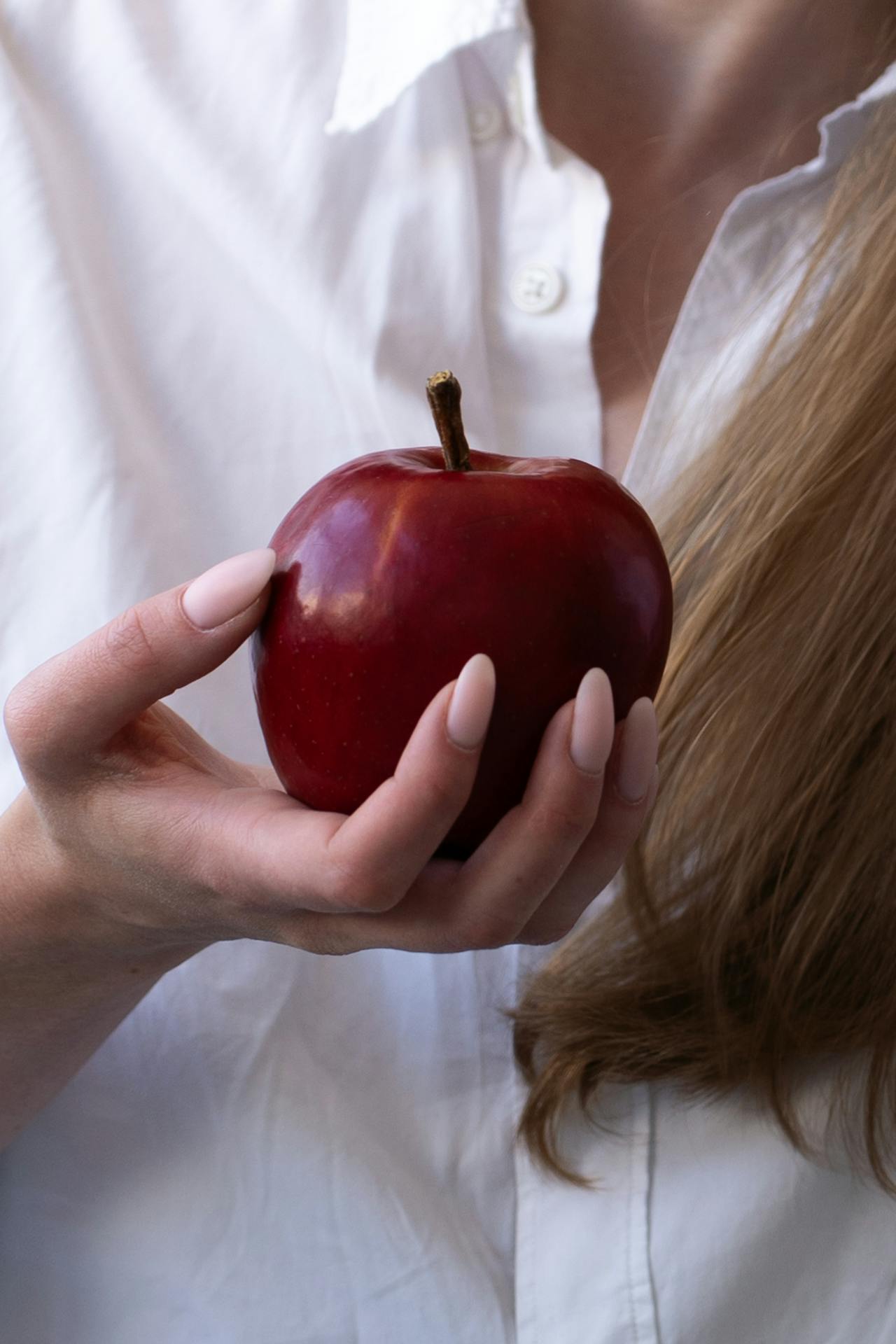 Une femme tenant une pomme | Source : Pexels