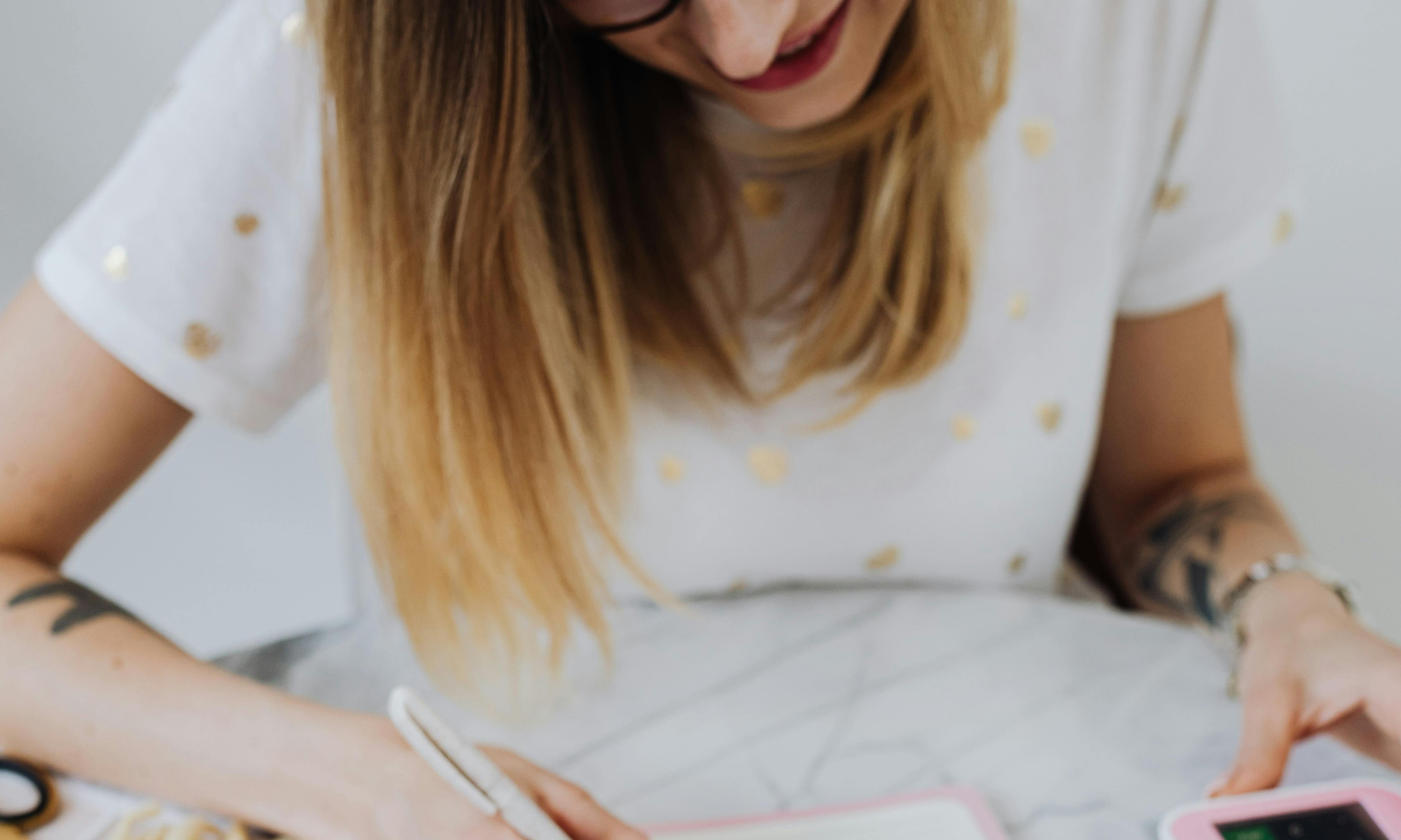 Une femme faisant des calculs avec un stylo à la main | Source : Pexels