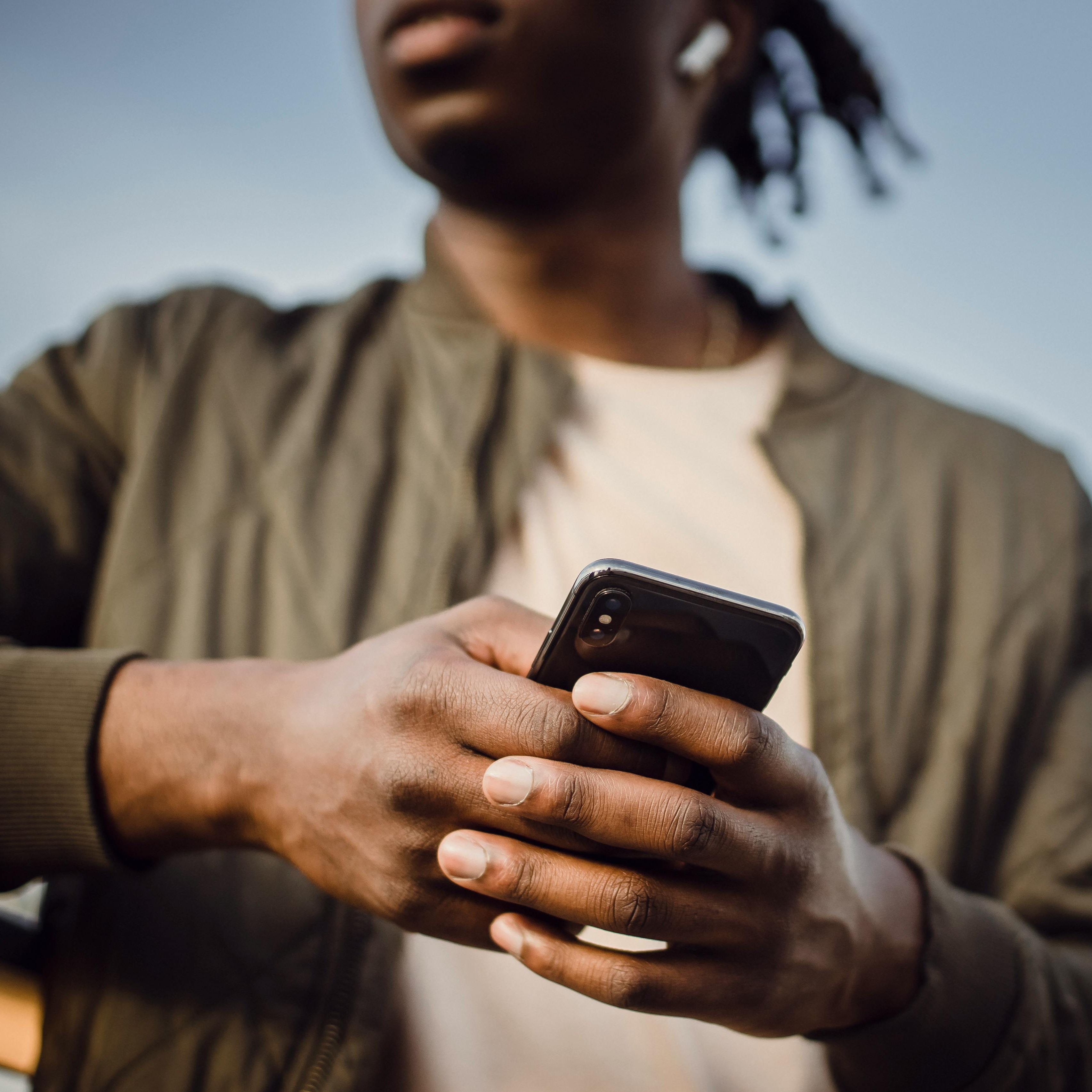 Un homme passant un appel téléphonique mobile à l'aide d'oreillettes | Source : Pexels