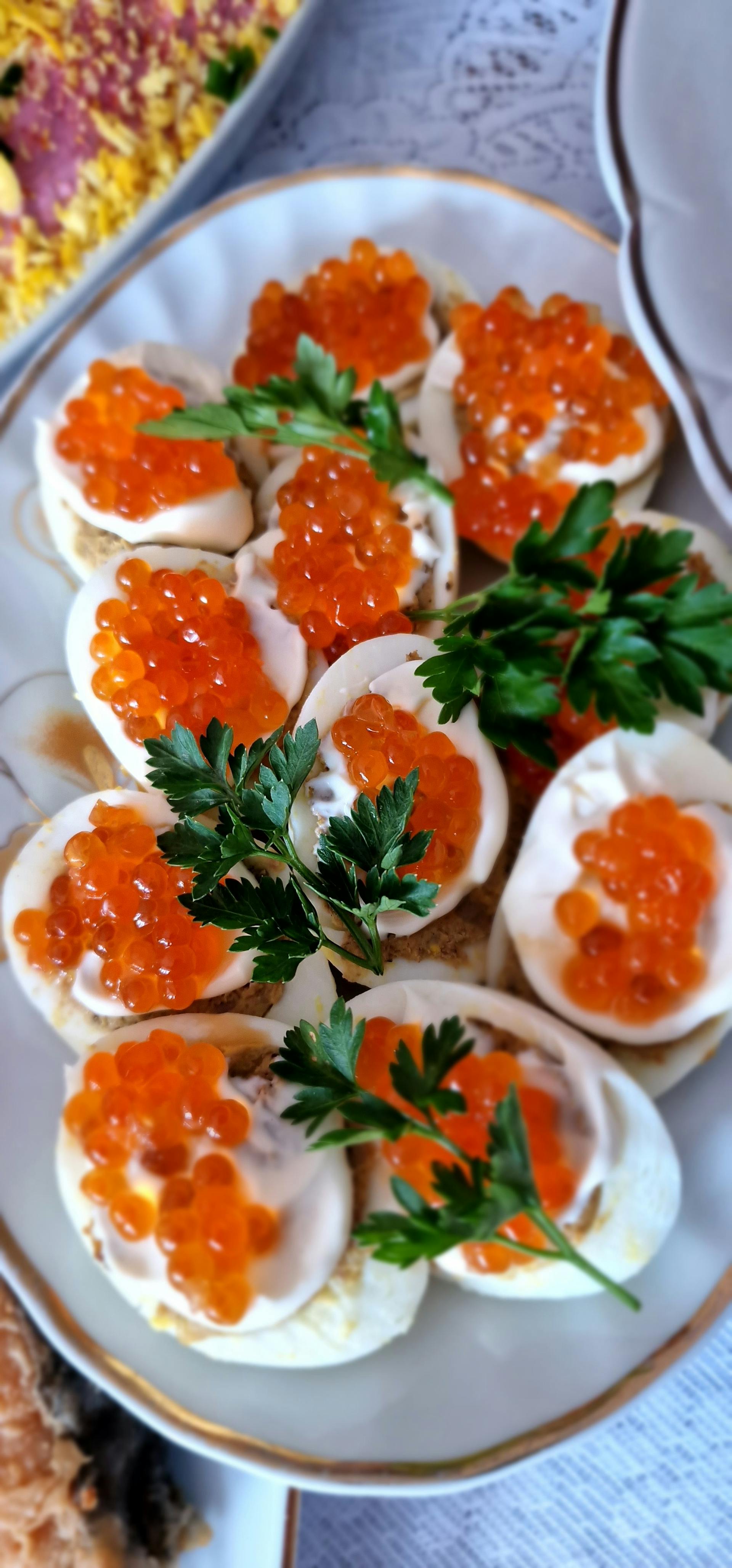 Une photo montrant des œufs mimosa gastronomiques garnis de caviar rouge et de persil | Source : Pexels