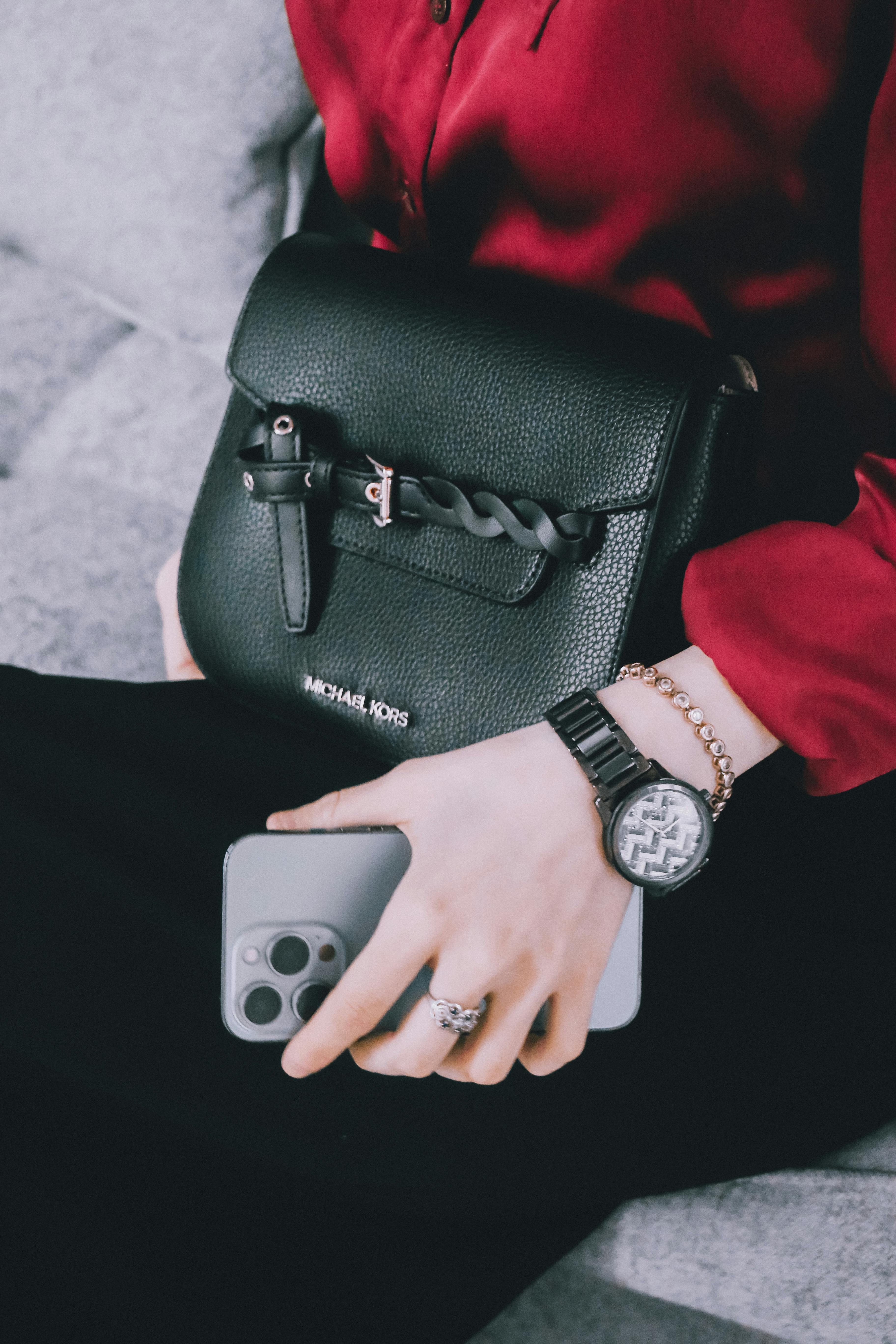 Une femme avec une montre, des bijoux, un téléphone et un sac coûteux | Source : Pexels