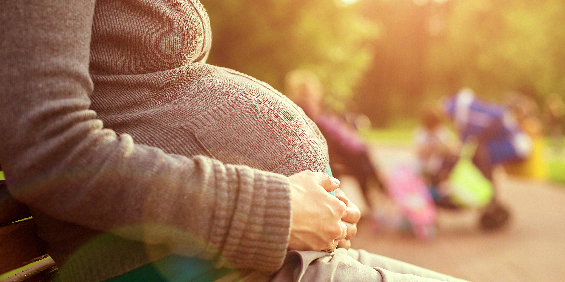 Une femme enceinte qui berce son baby bump en position assise | Source : Shutterstock