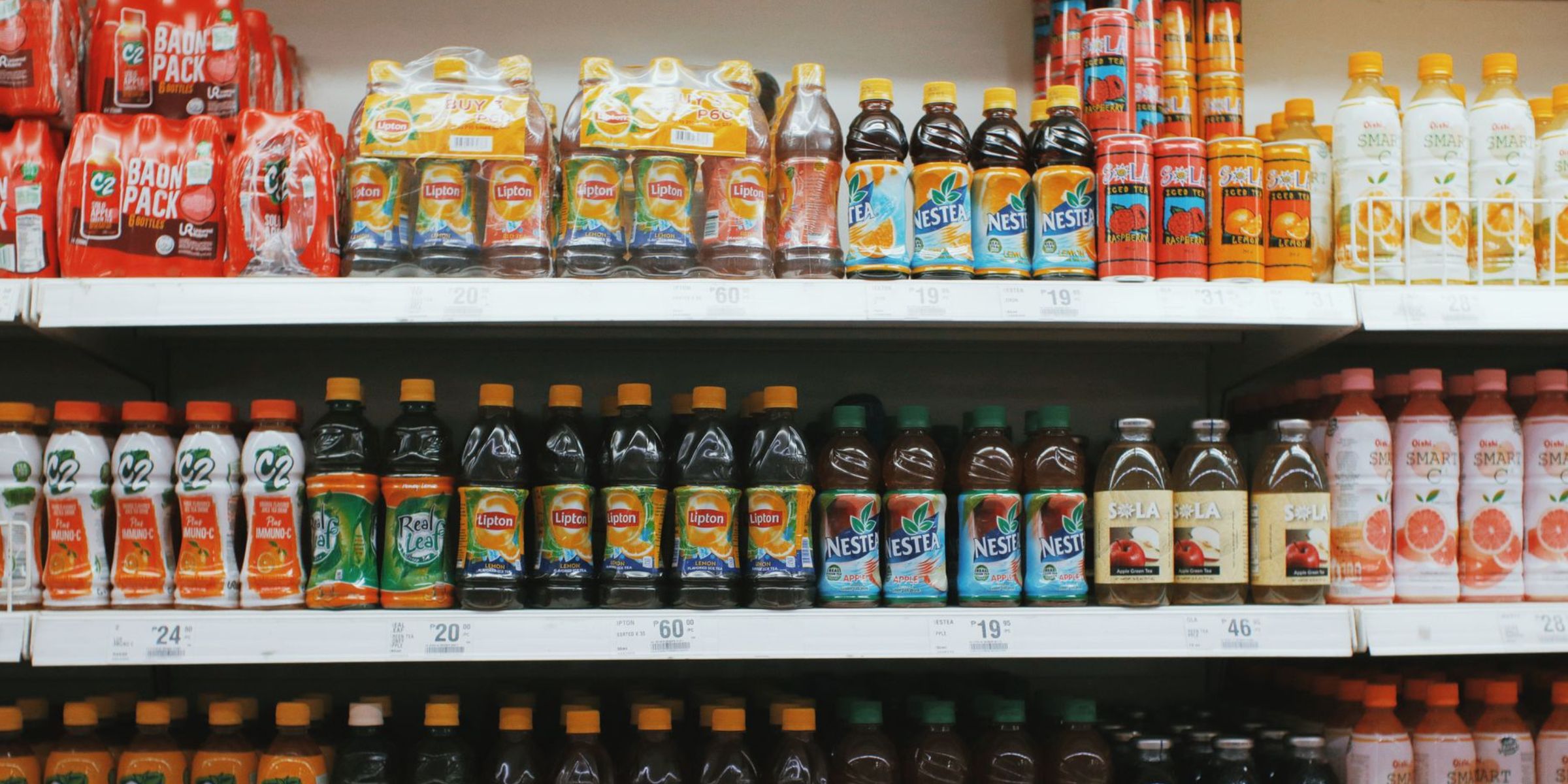 Des rangées colorées de boissons variées sur un rayon de supermarché | Source : Pexels