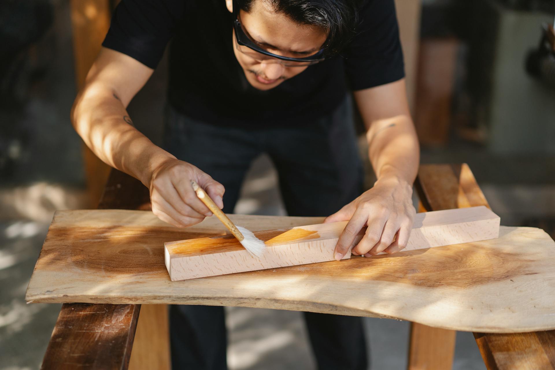 Un homme utilisant du vernis sur du bois | Source : Pexels