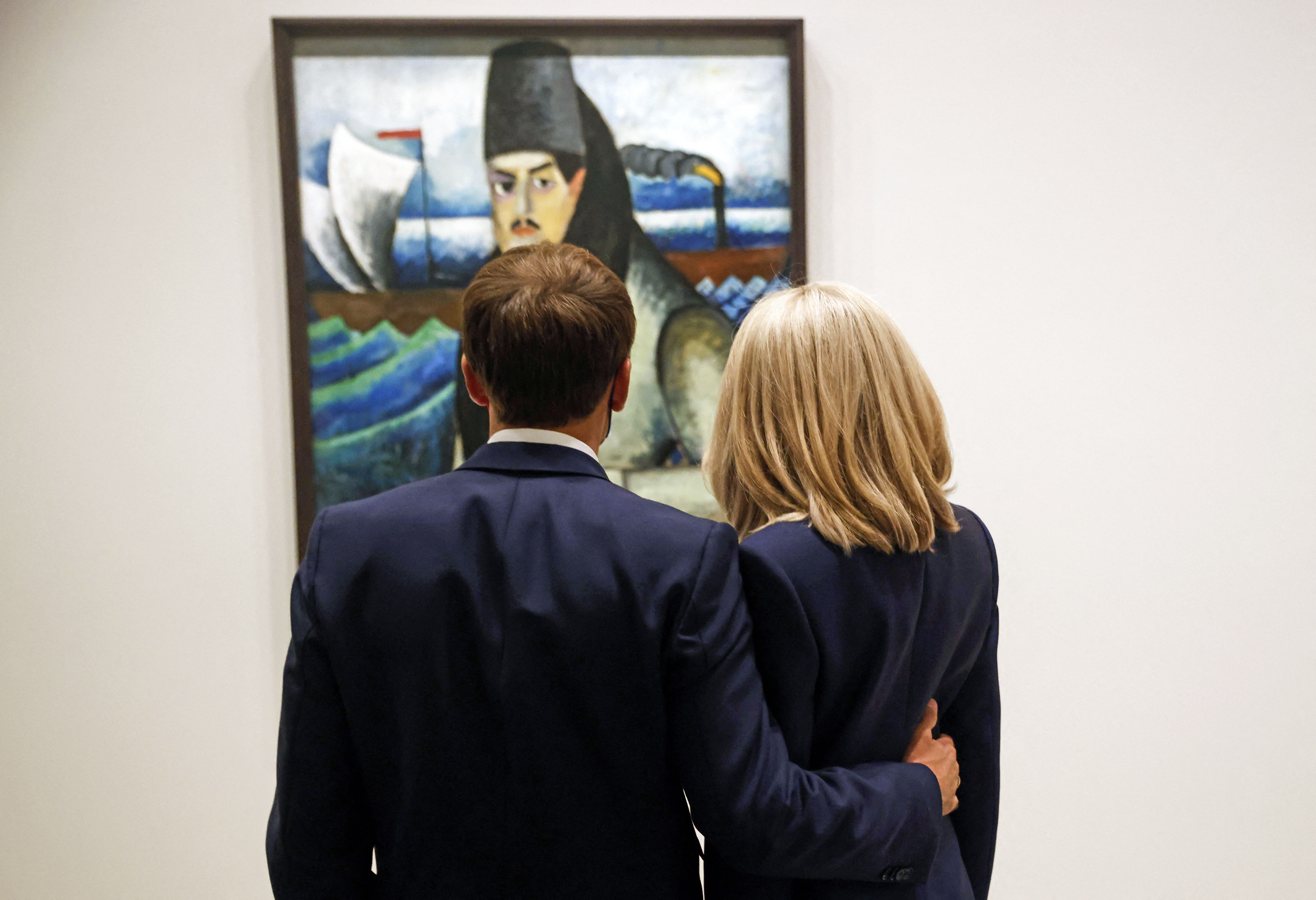 Les Macron se tiennent côte à côte, admirant un tableau lors du vernissage de l'exposition "La collection Morozov, icônes de l'art moderne" à la Fondation Louis Vuitton à Paris, le 21 septembre 2021.